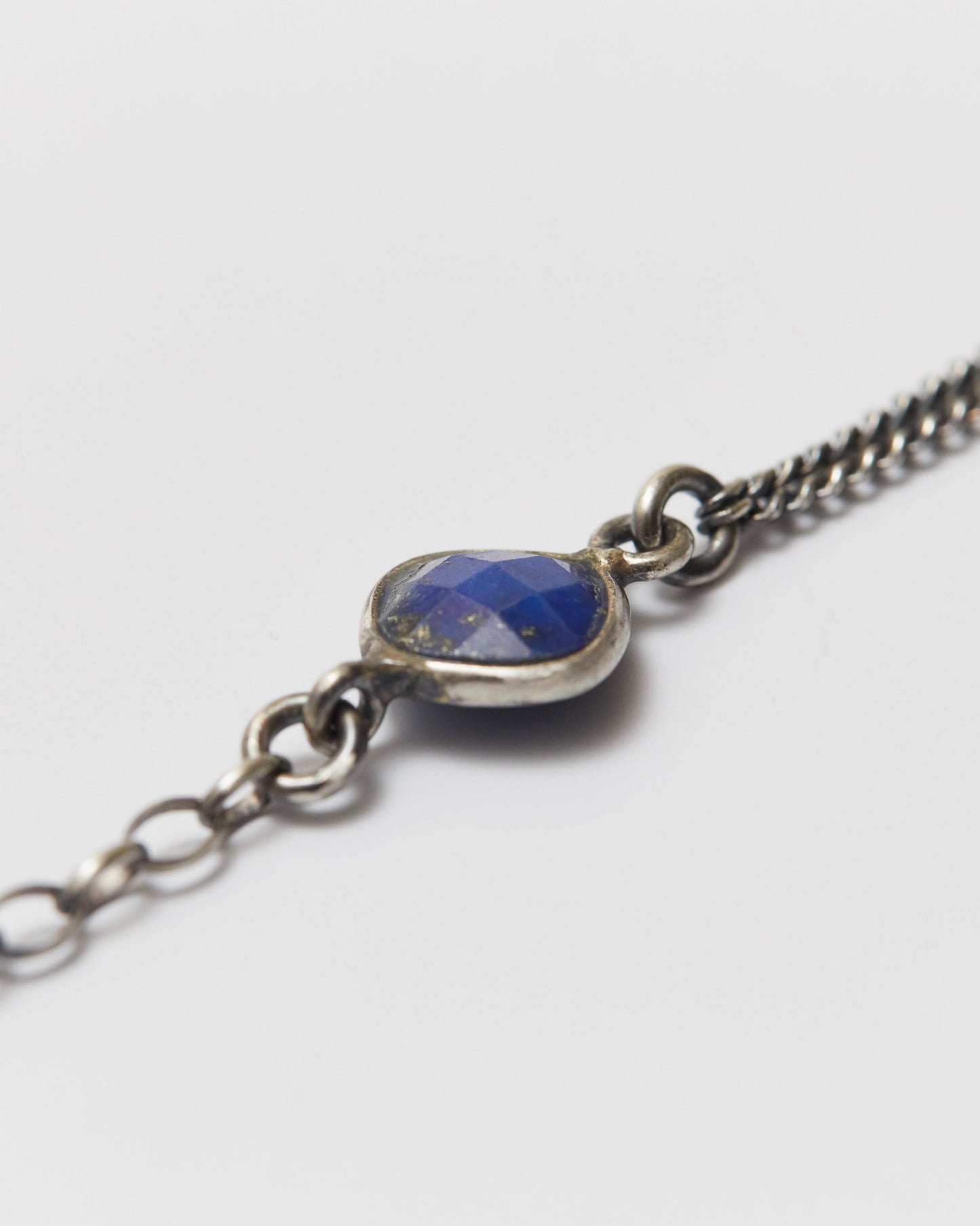Silver bracelet with a blue stone on a white background