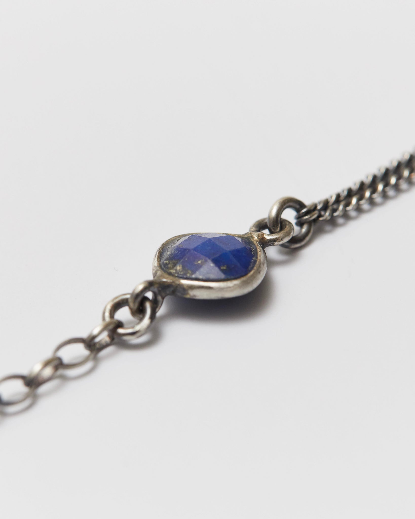 Silver bracelet with a blue stone on a white background