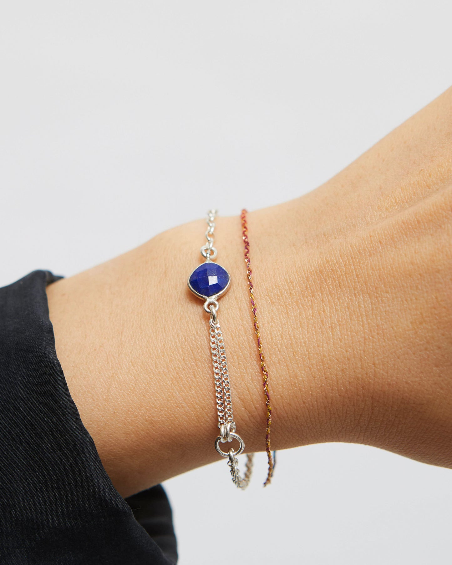 Bracelets on a wrist with a plain background
