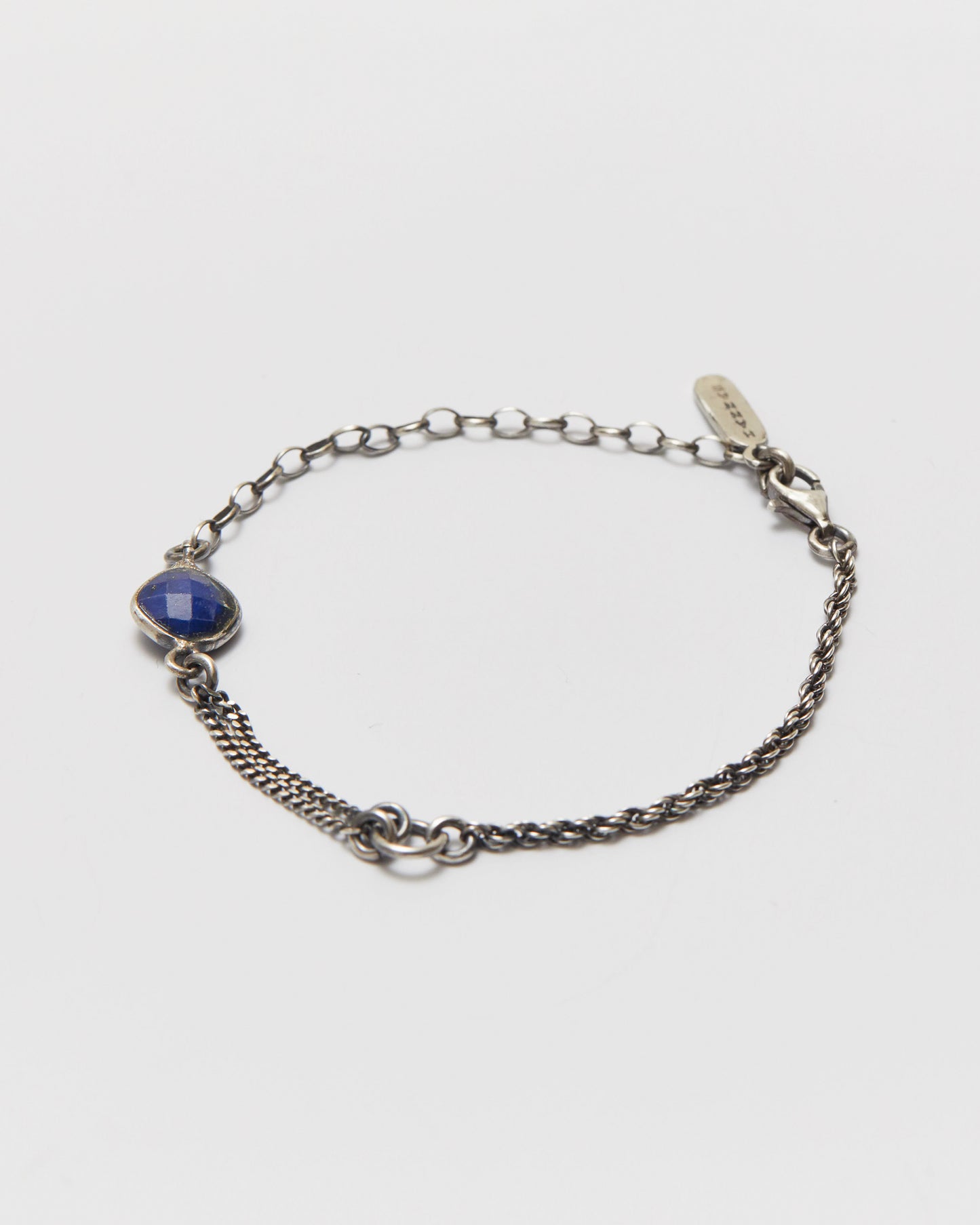 Silver chain bracelet with a blue gemstone on a white background