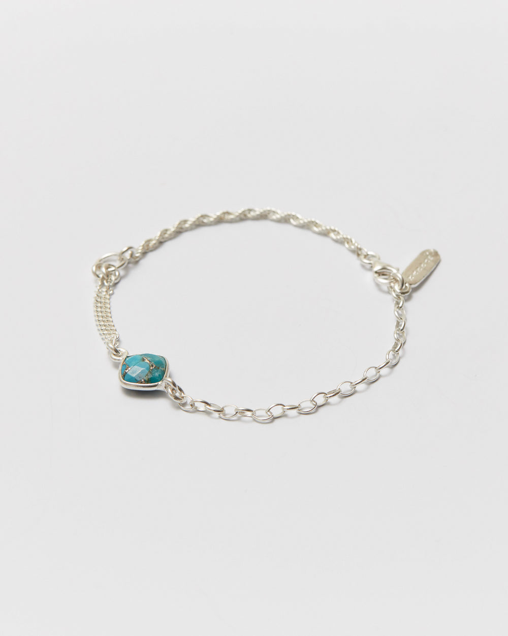 Silver bracelet with a turquoise stone on a light gray background
