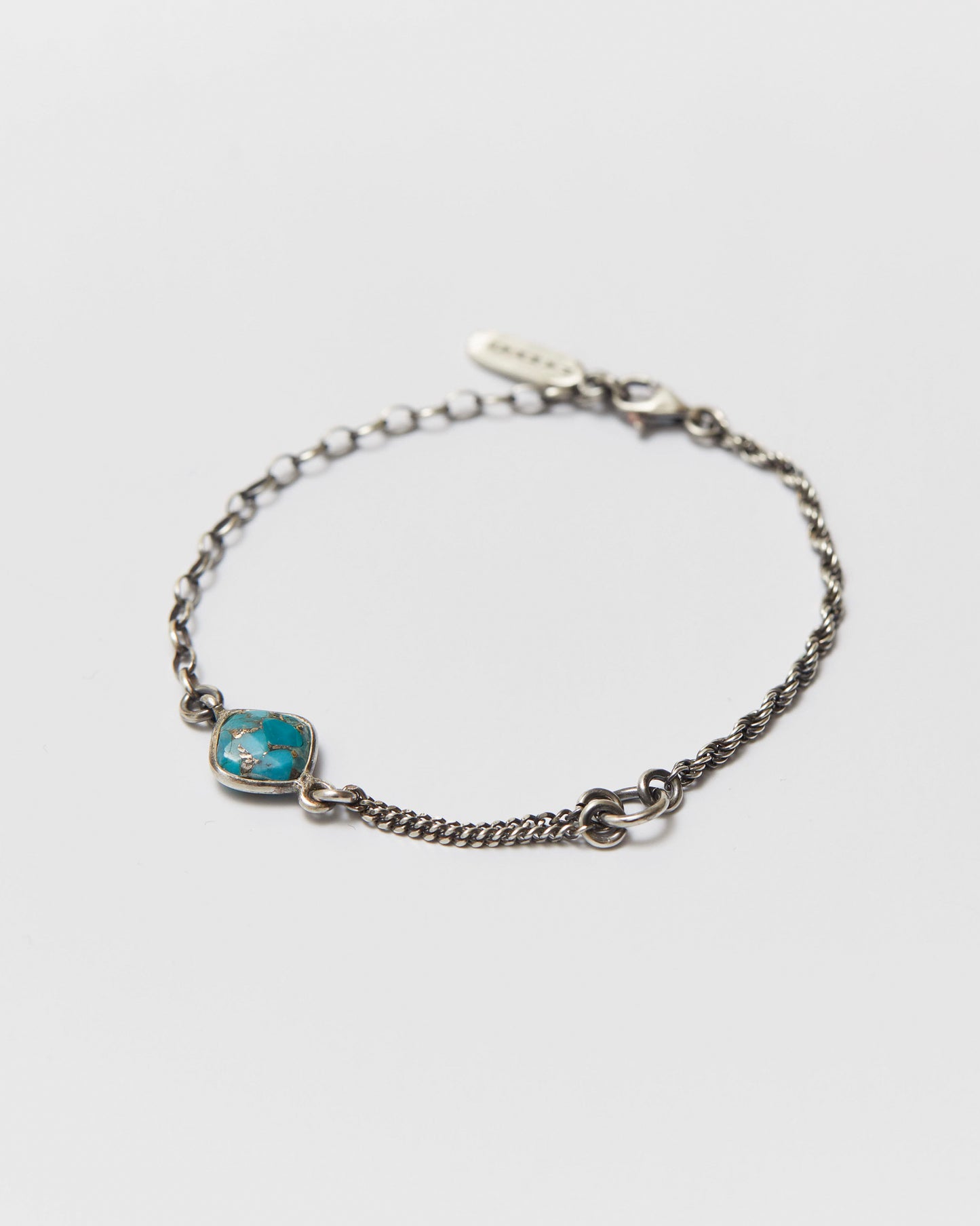 antique silver bracelet with a blue stone on a light gray background