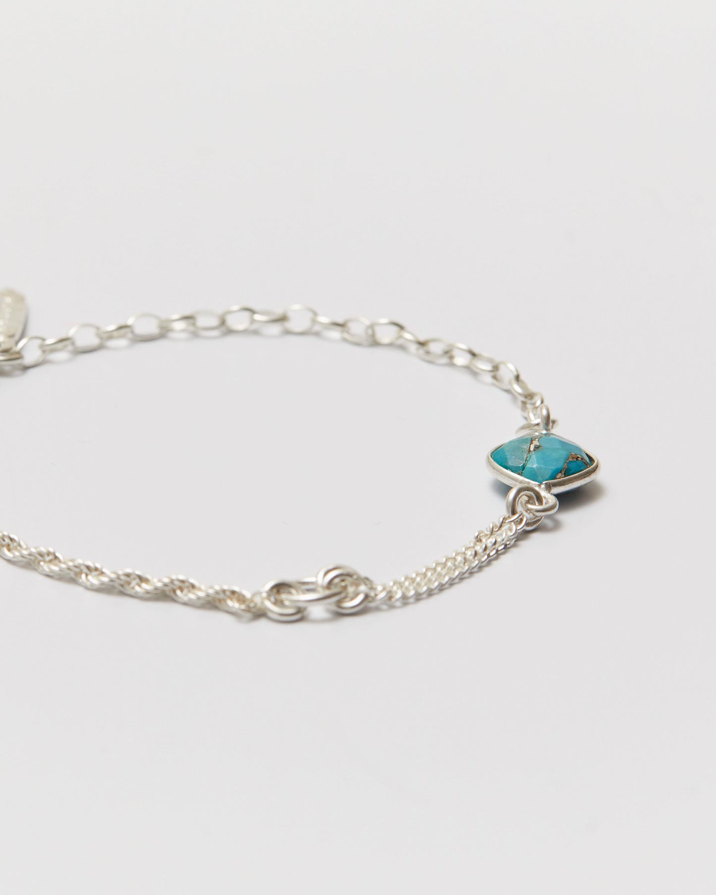 Silver bracelet with a turquoise stone on a light gray background