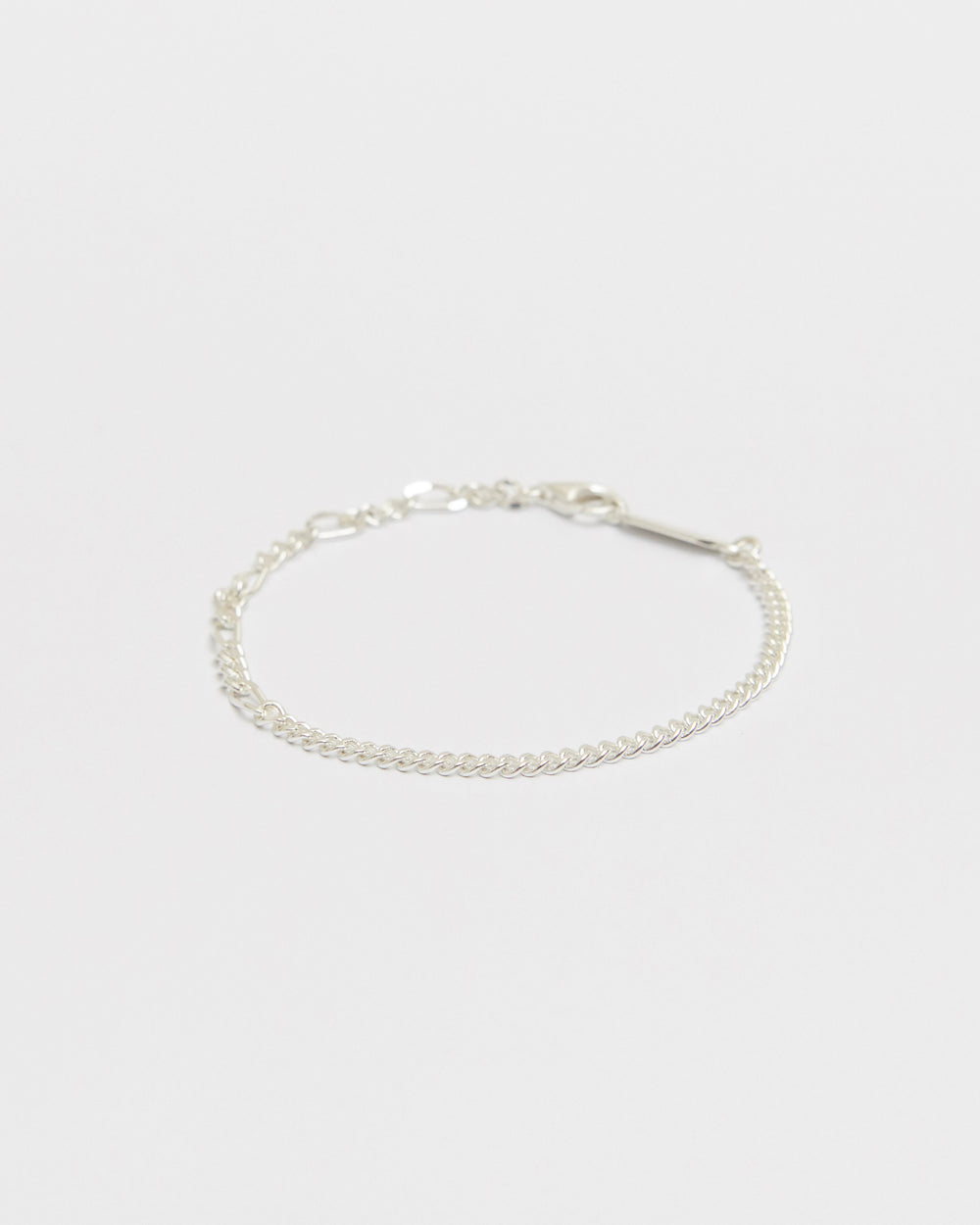 Minimal sterling silver mixed chain bracelet featuring delicate curb links and elongated chain details on a clean white background for everyday wear.