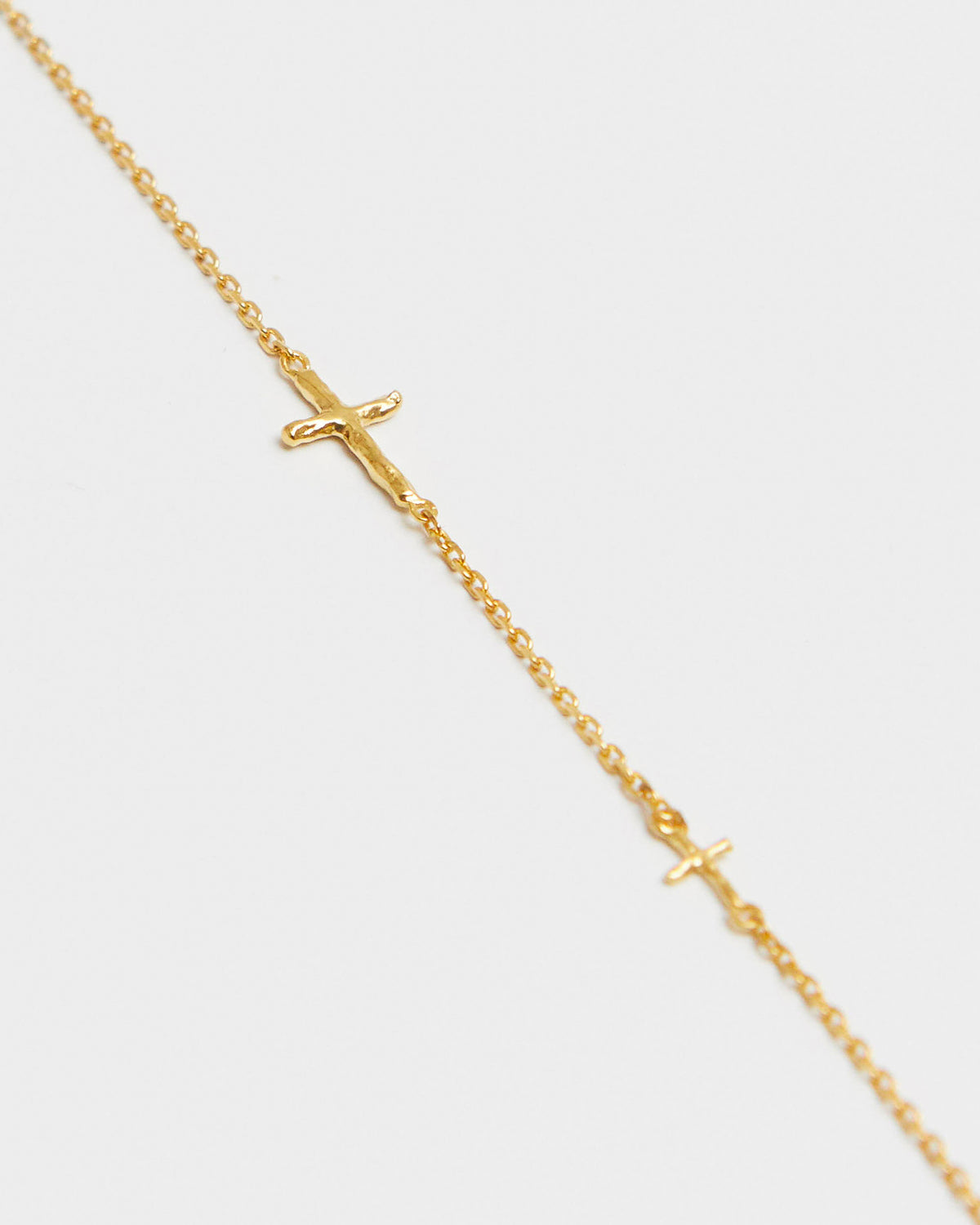 cross axis chain bracelet in gold – close-up of the small cross charm on a fine chain | HANNA543