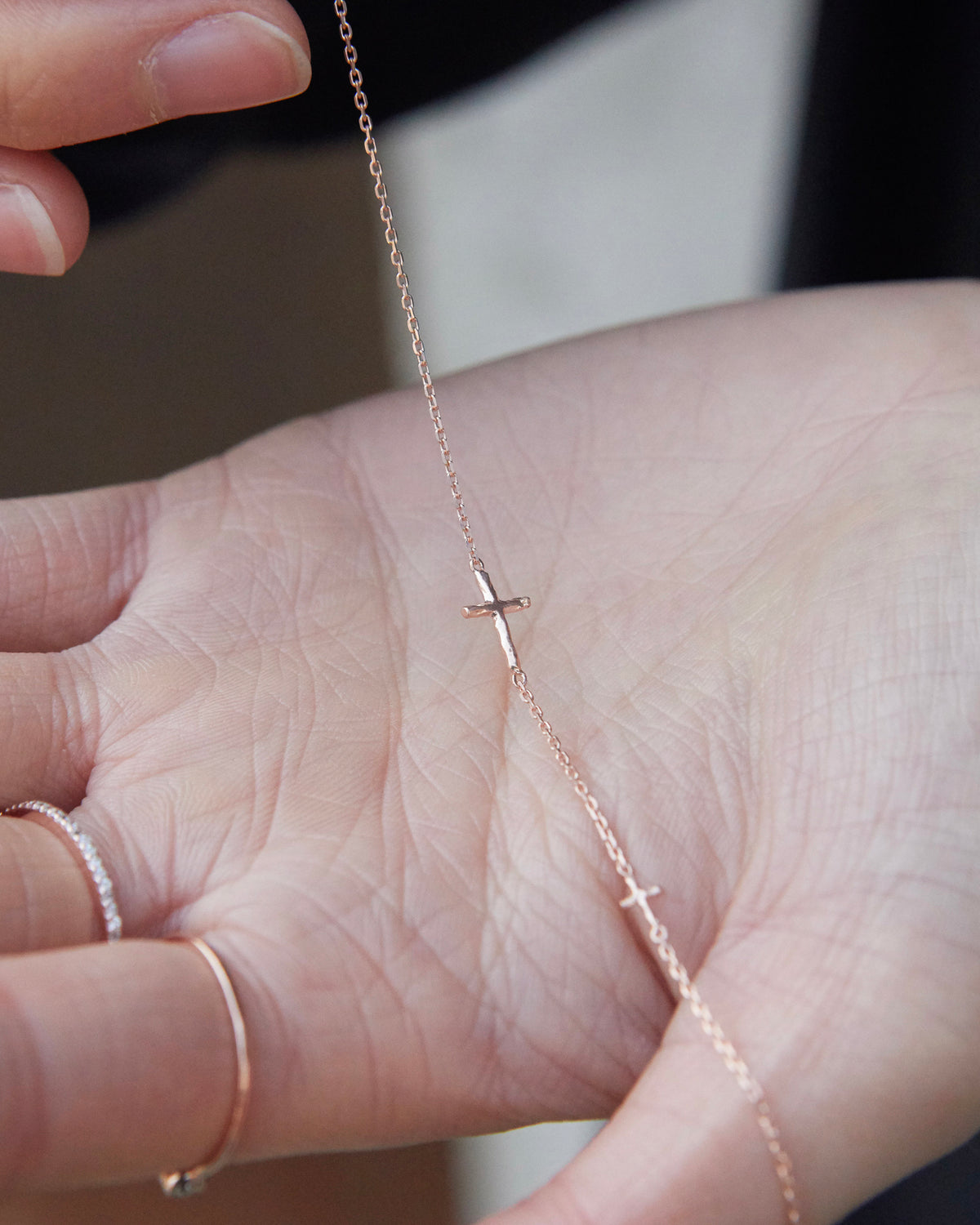 cross axis chain bracelet in pink gold – draped across an open palm to show the fine chain | HANNA543