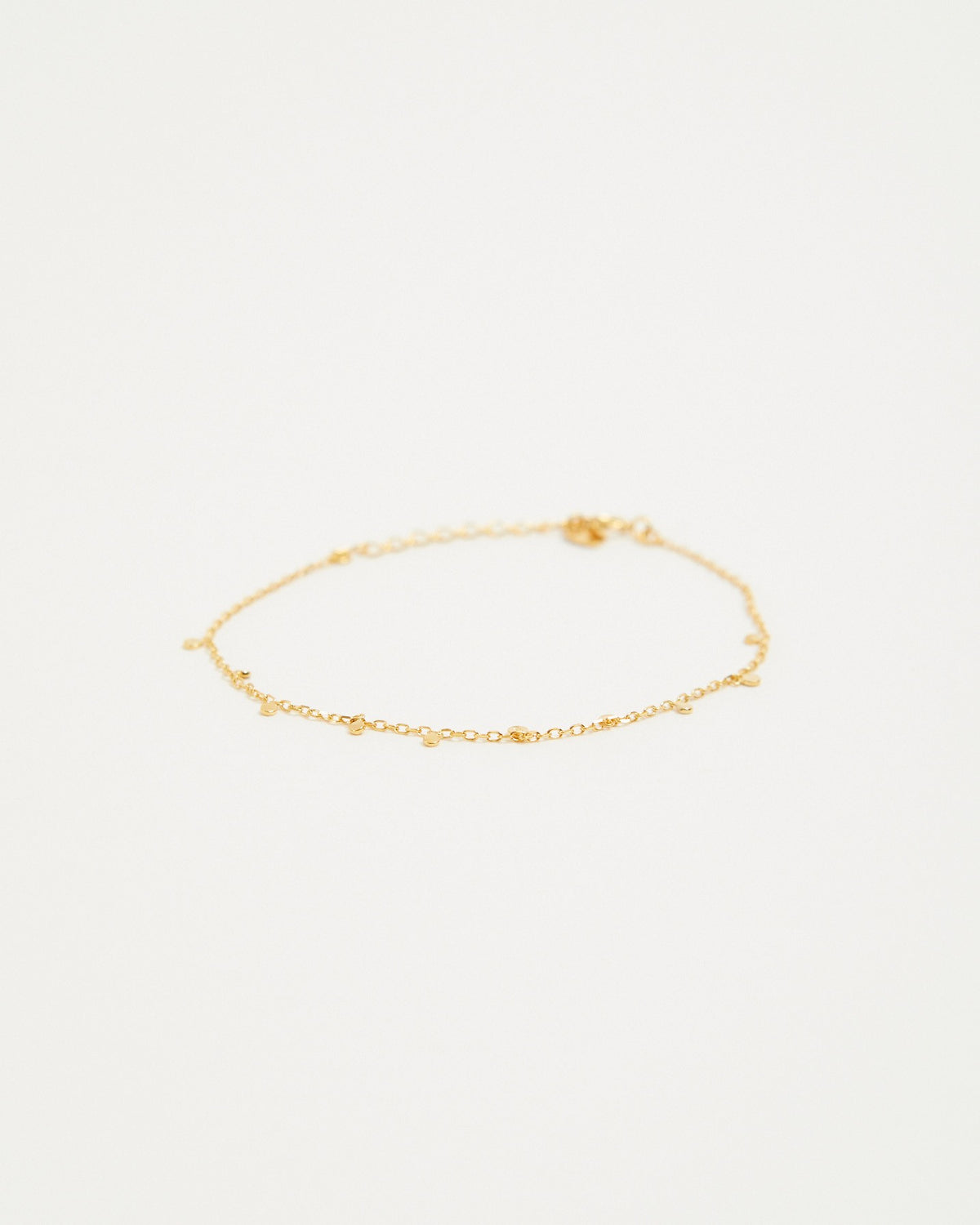 Gold plated dot station chain bracelet laid flat on a light background – HANNA543 B96 dew drop garland