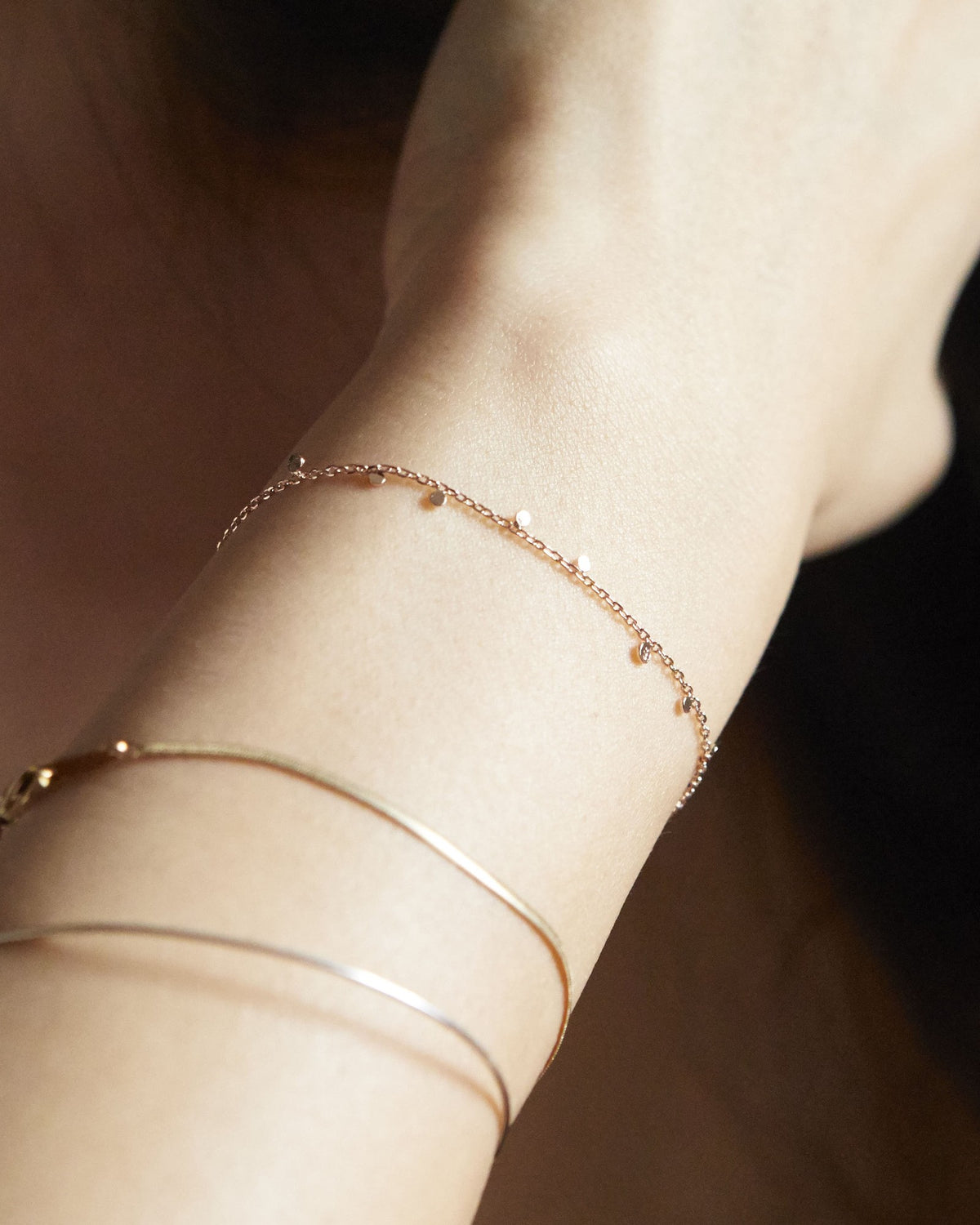 Wrist wearing a rose gold dot chain bracelet with bangles – HANNA543 B96 dew drop garland
