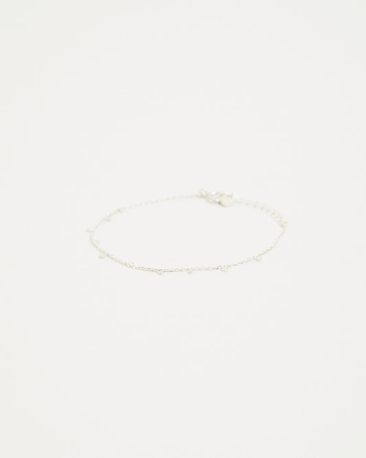 Sterling silver dot station chain bracelet laid flat on a light background – HANNA543 B96 dew drop garland