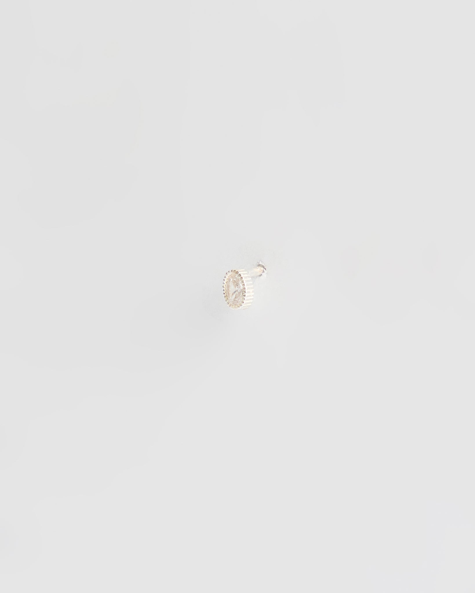 Small oval-shaped earring on a light gray background