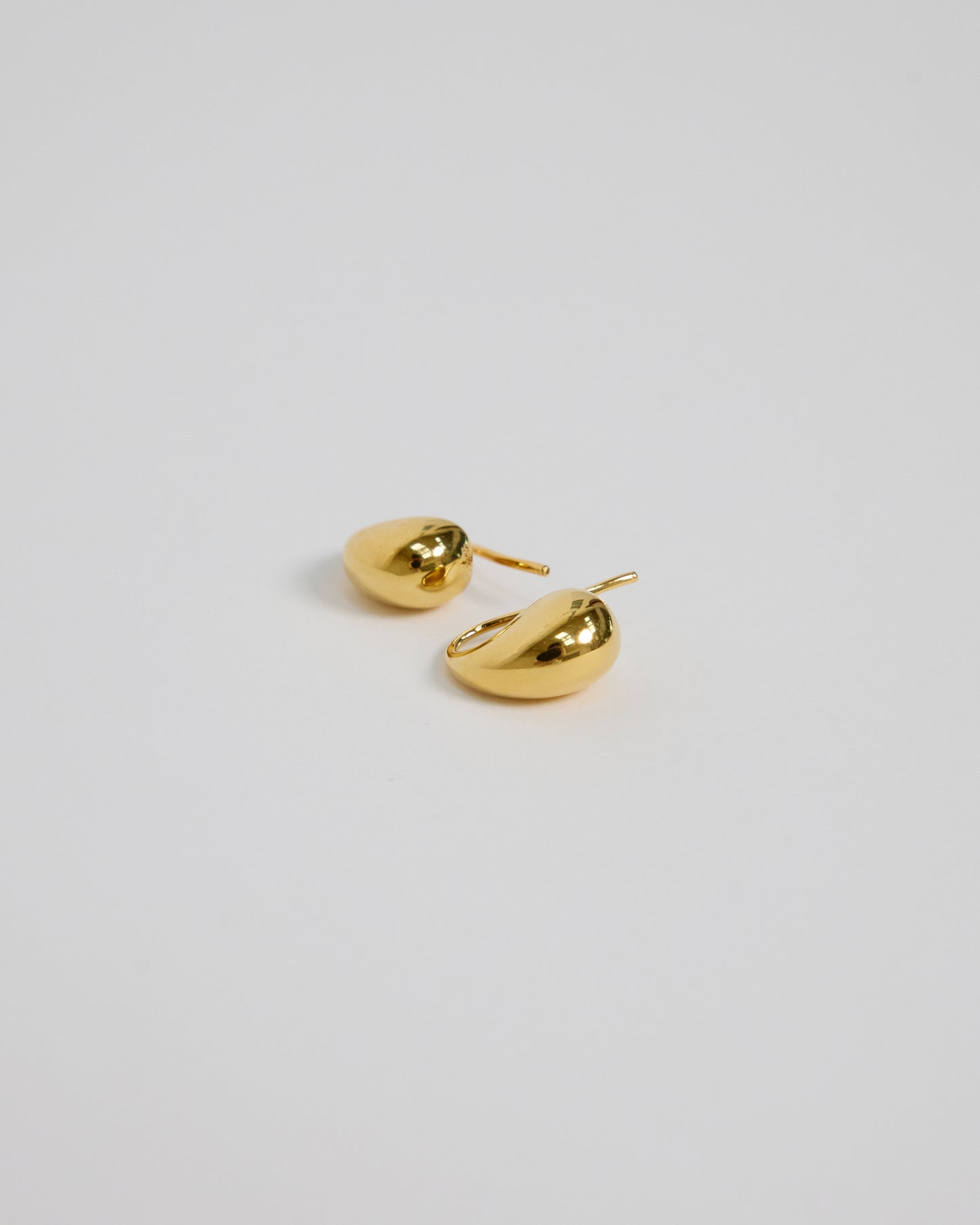 Pair of HANNA543 18k gold plated over sterling silver bold teardrop earrings, featuring a luxurious liquid-form design.