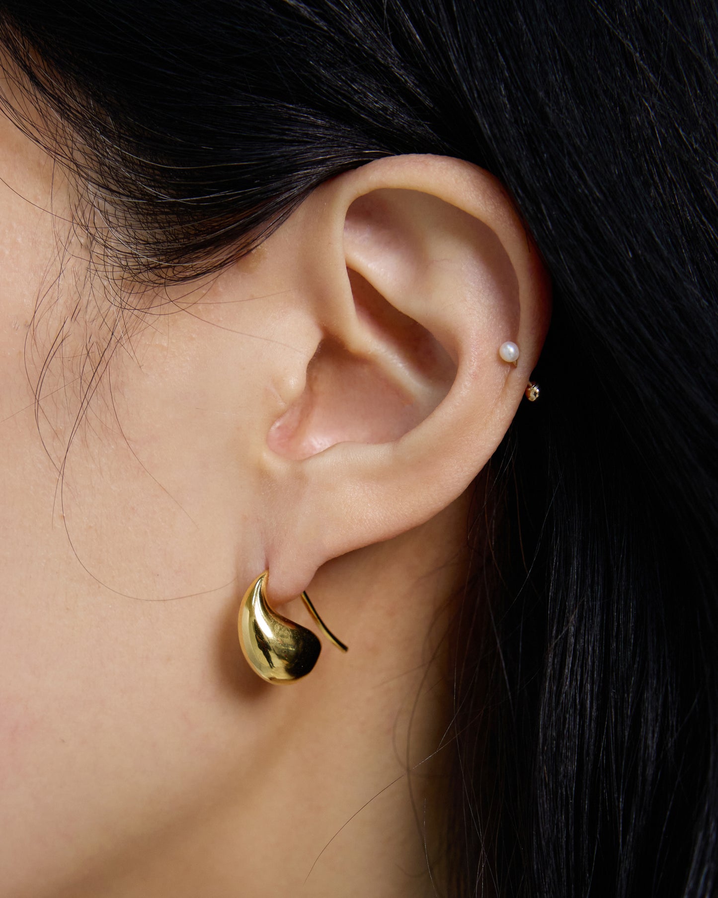 Gold curved hook earrings backside view, minimalist ergonomic design