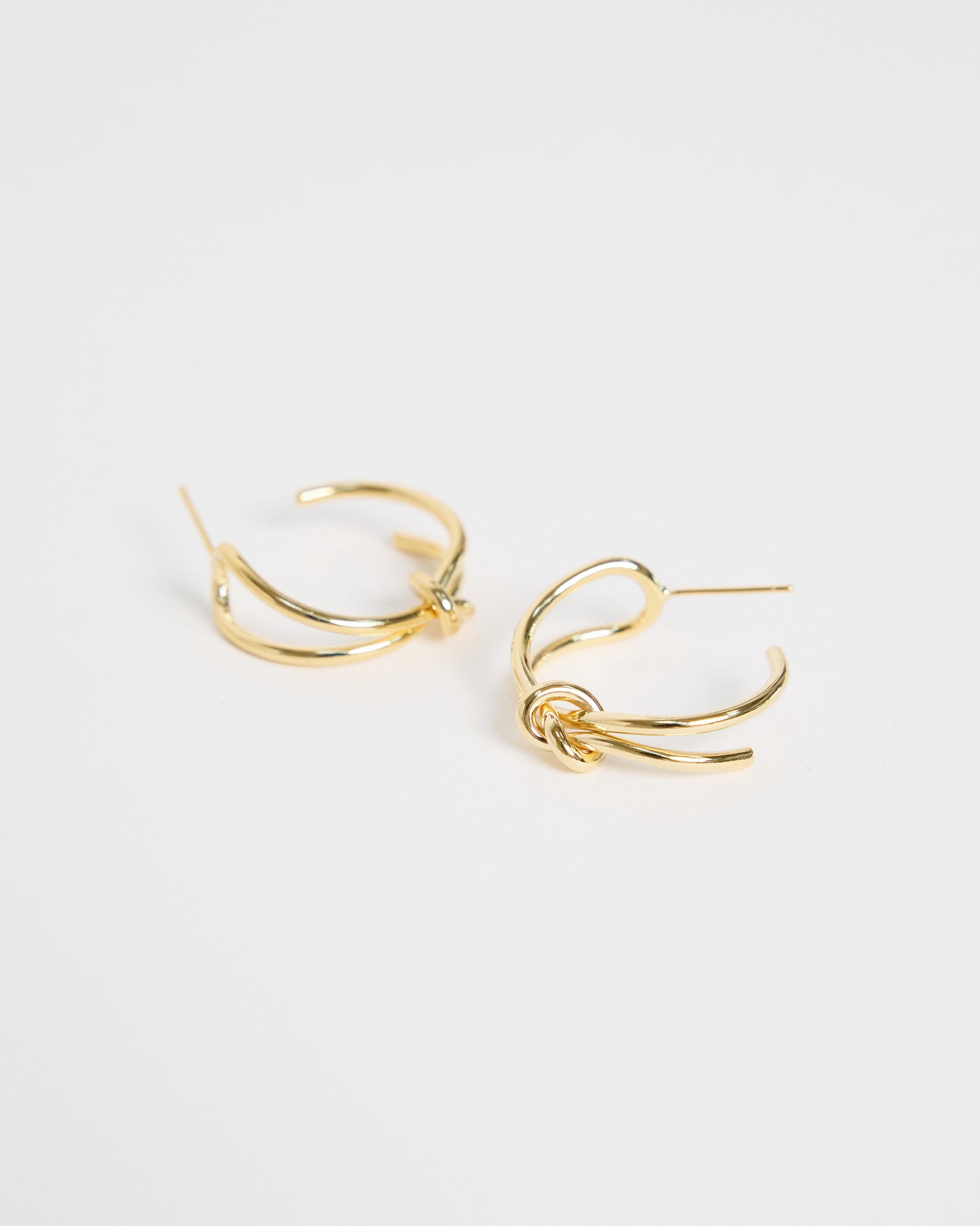 gold knot hoop earrings minimal double hoop design everyday jewelry clean studio product shot gold plated earrings