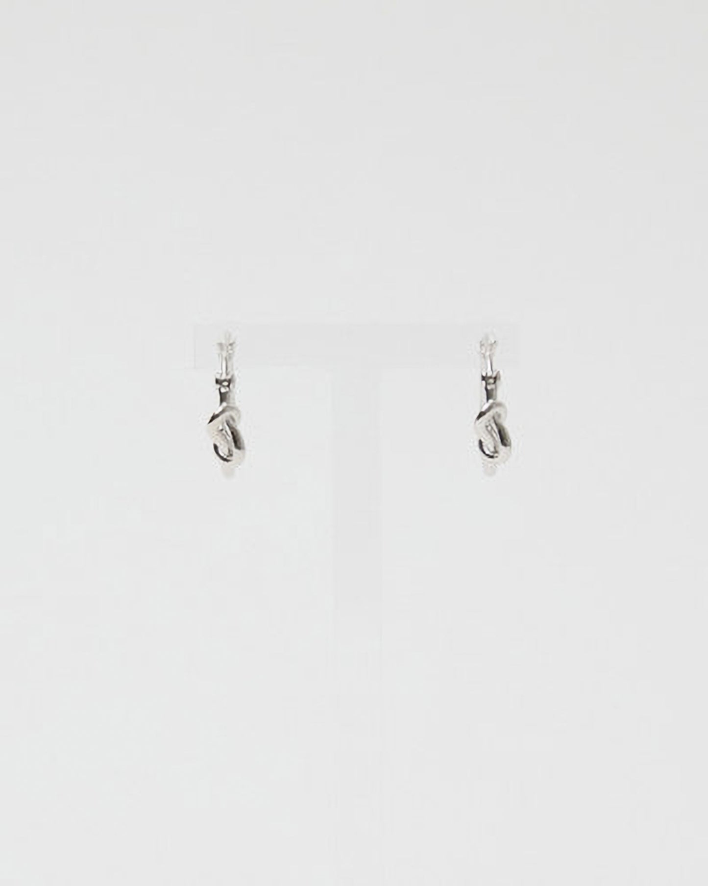 Pair of silver earrings on a light gray background