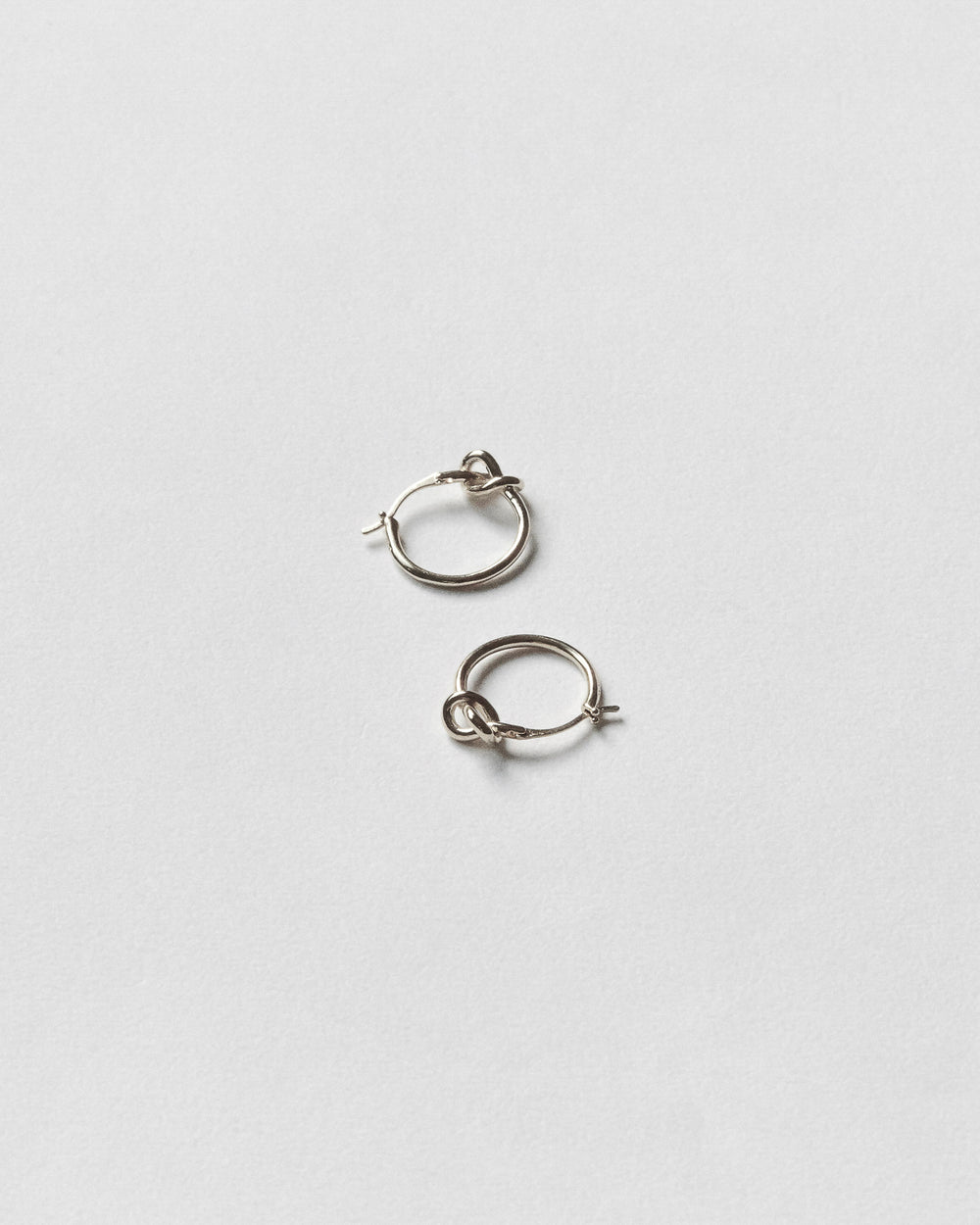 Pair of silver hoop earrings on a light gray background