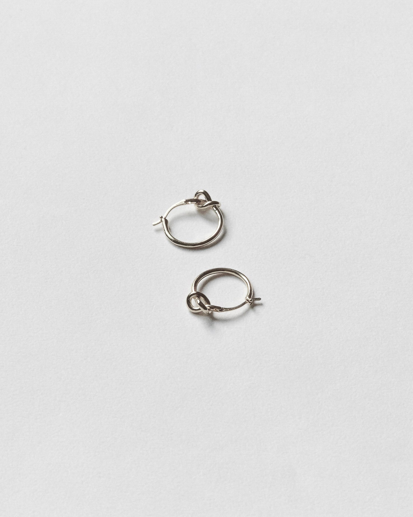 Pair of silver hoop earrings on a light gray background