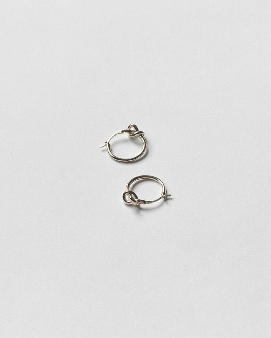 Pair of silver hoop earrings on a light gray background