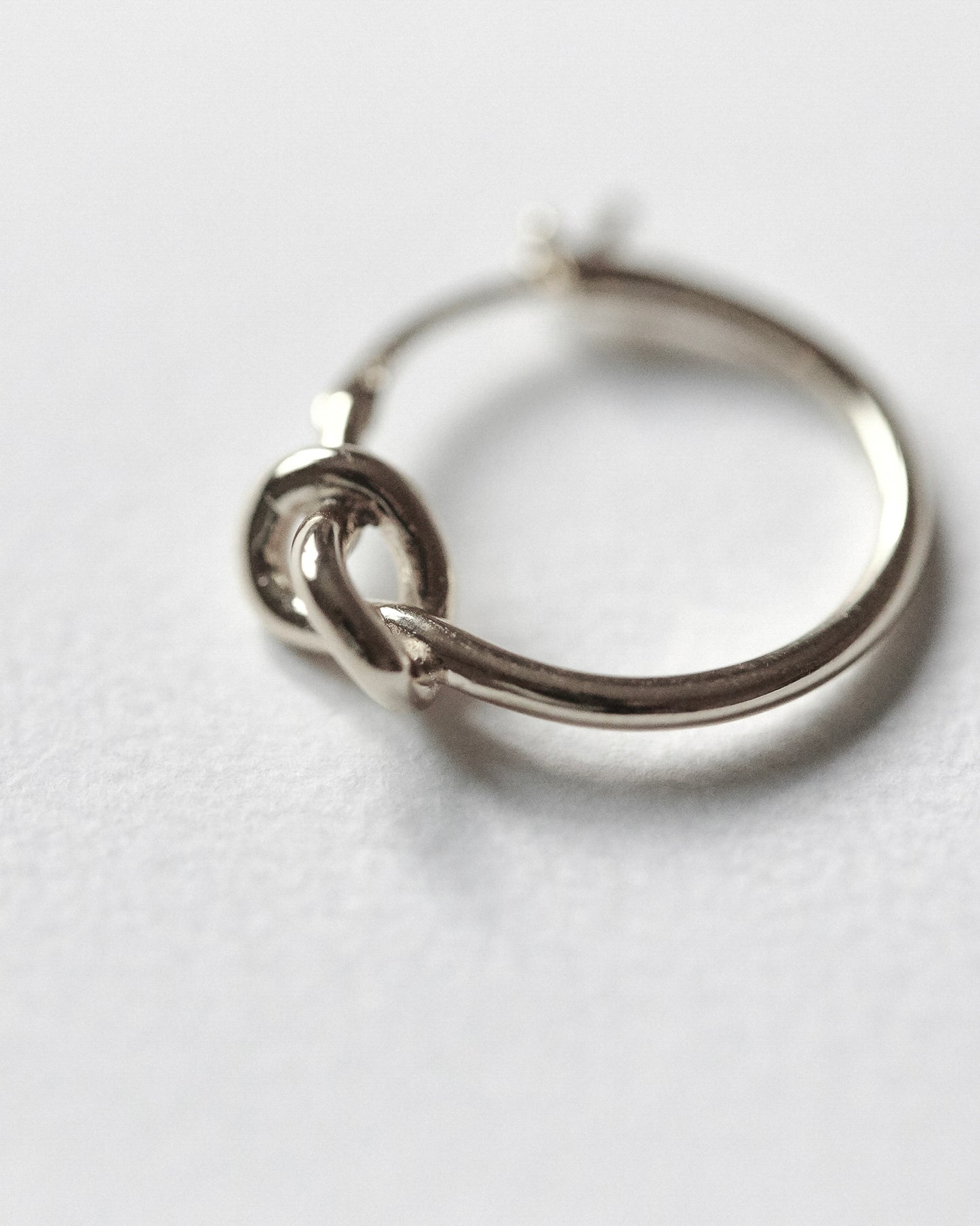 Silver hoop earring on a white background