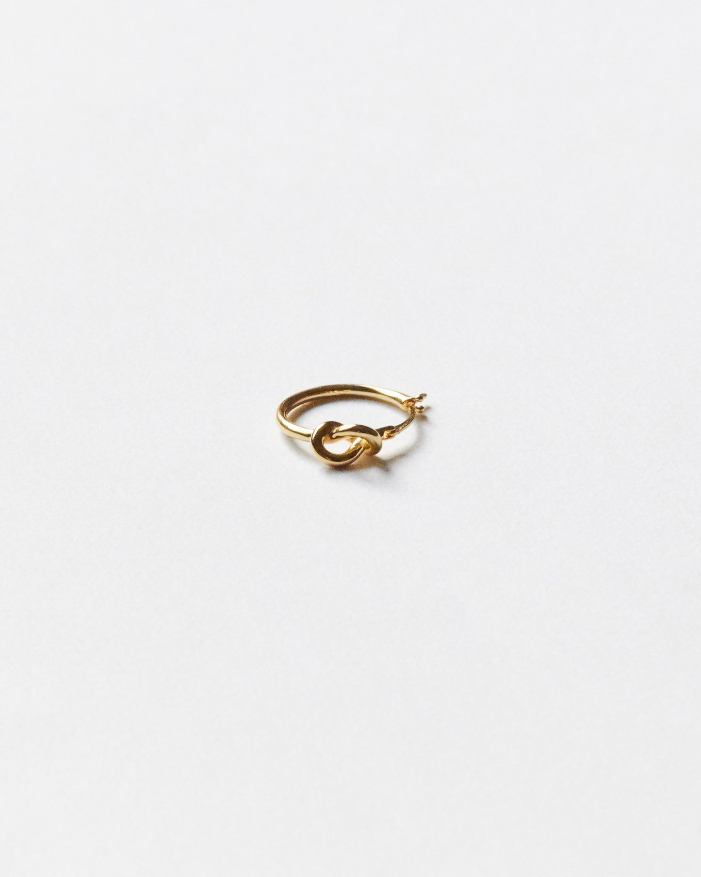 Gold hoop earring on a white background