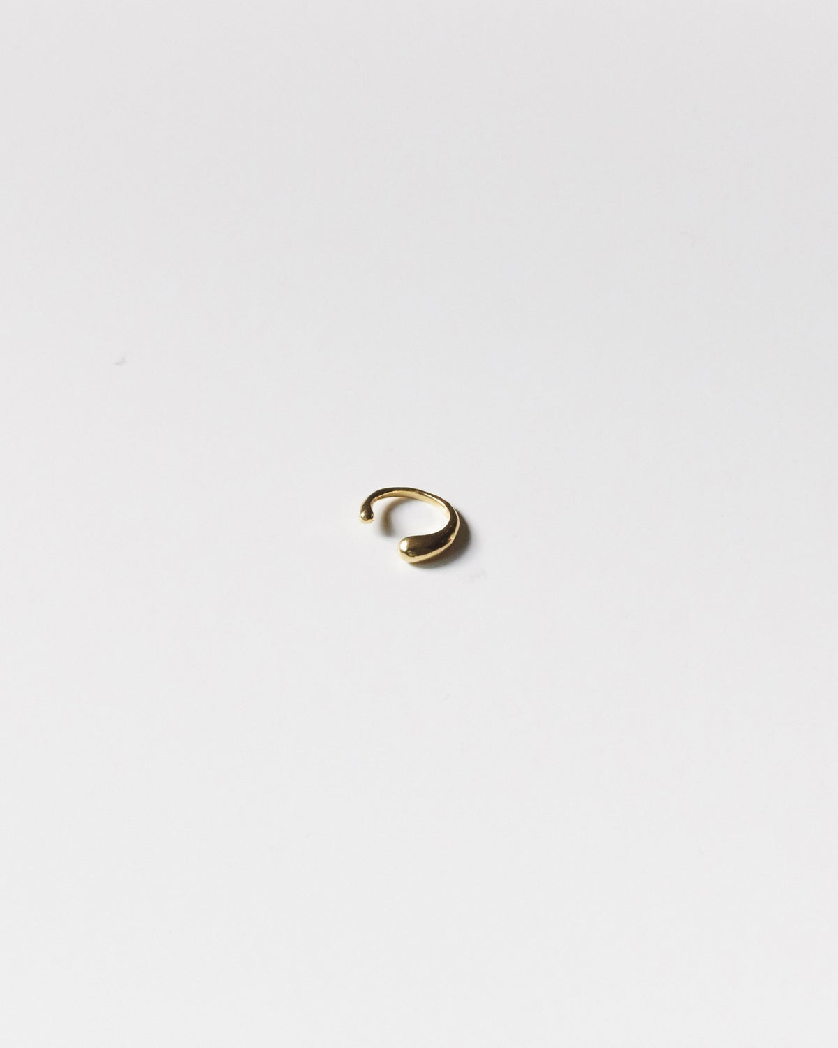 Small gold plated drop ear cuff on a light gray background – HANNA543 E735 falling drop cuff