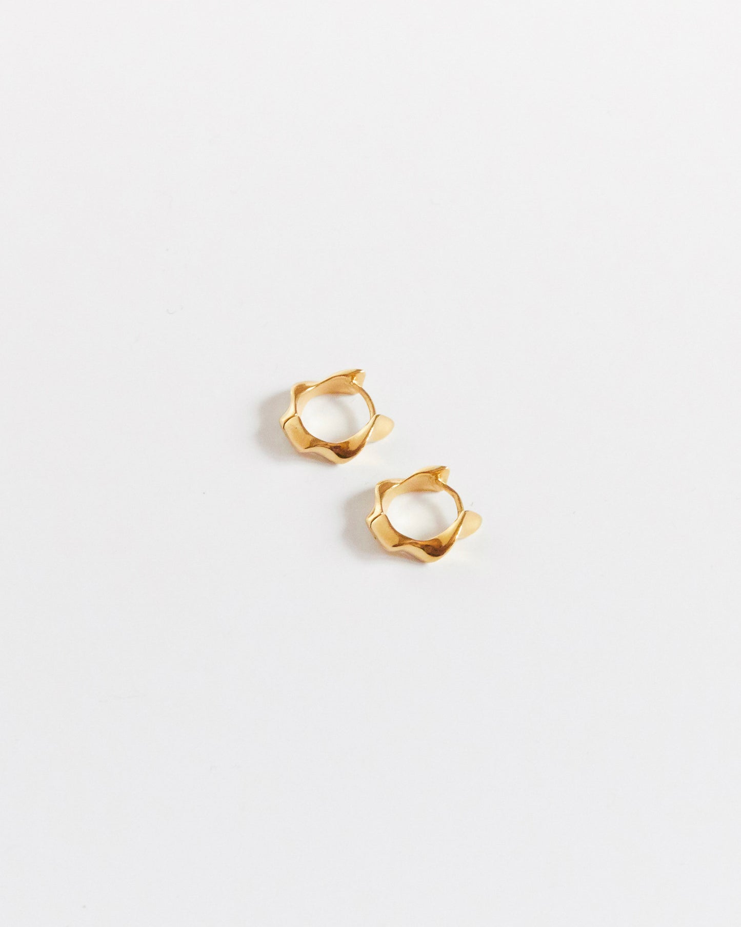 gold earrings fitting on a white background