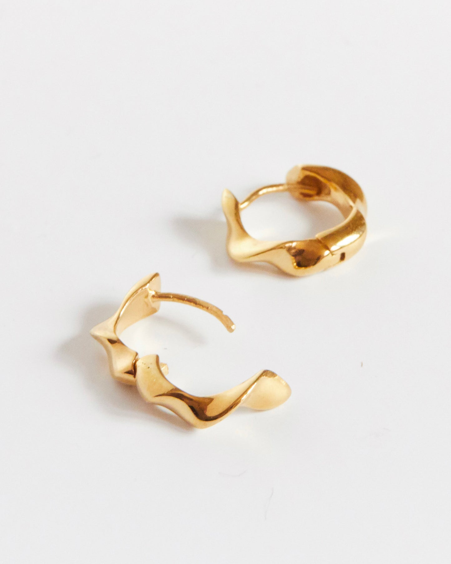 Gold hoop earrings on a light gray background