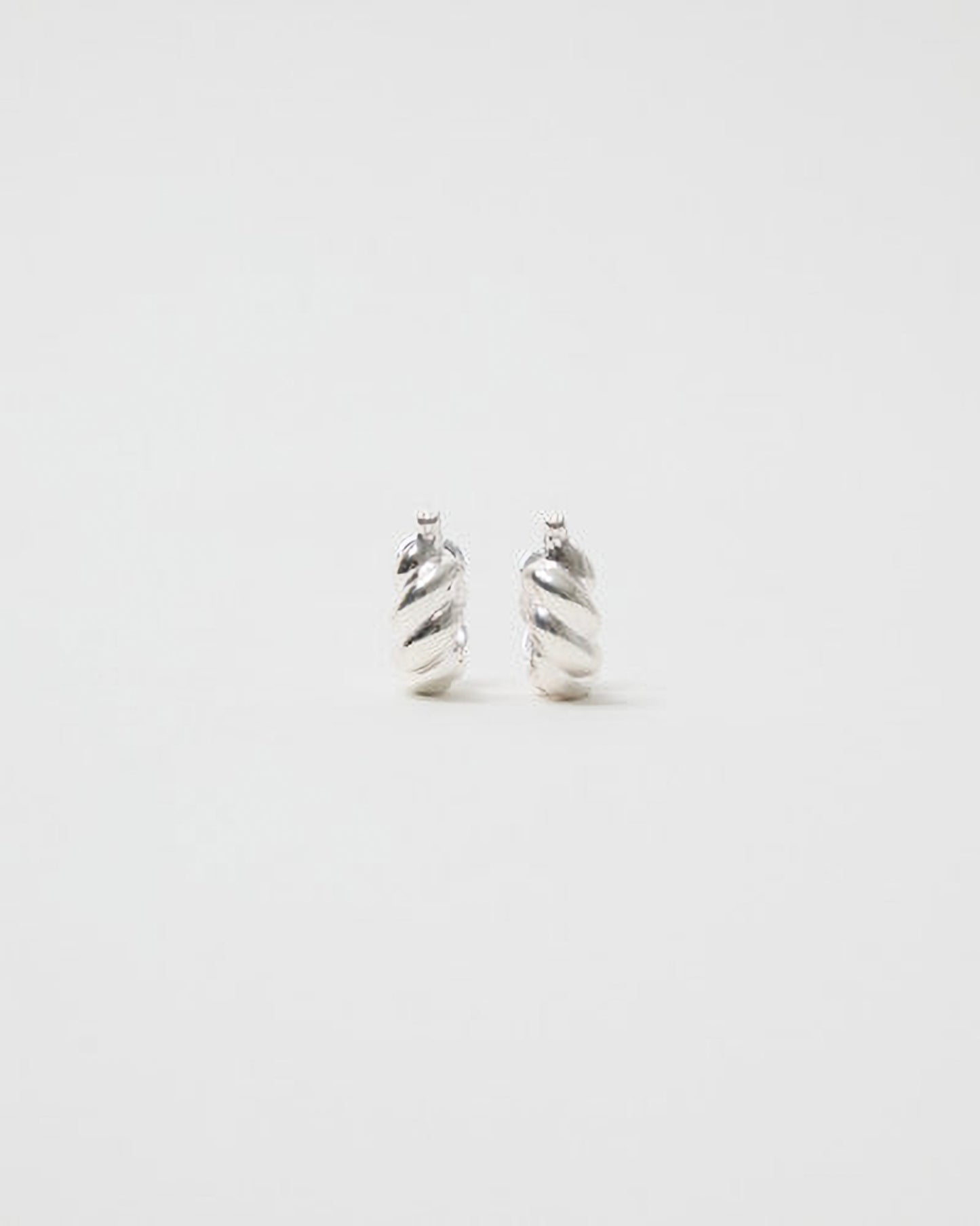 Pair of silver spiral earrings on a white background