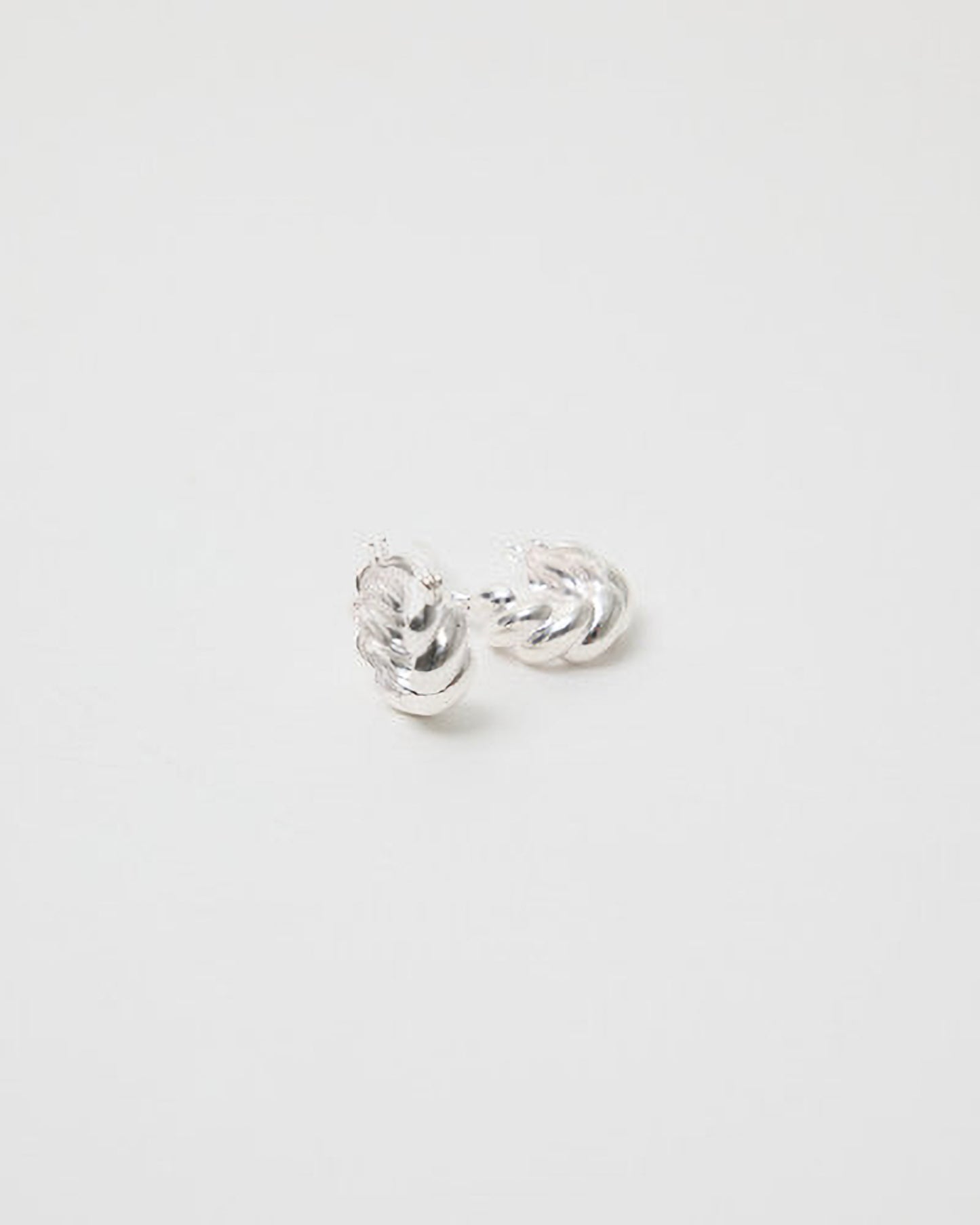 Silver earrings on a light gray background