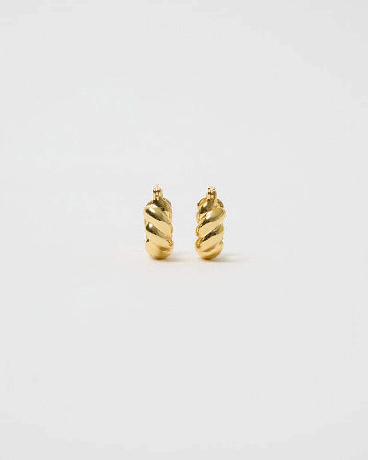 Pair of gold hoop earrings on a light gray background