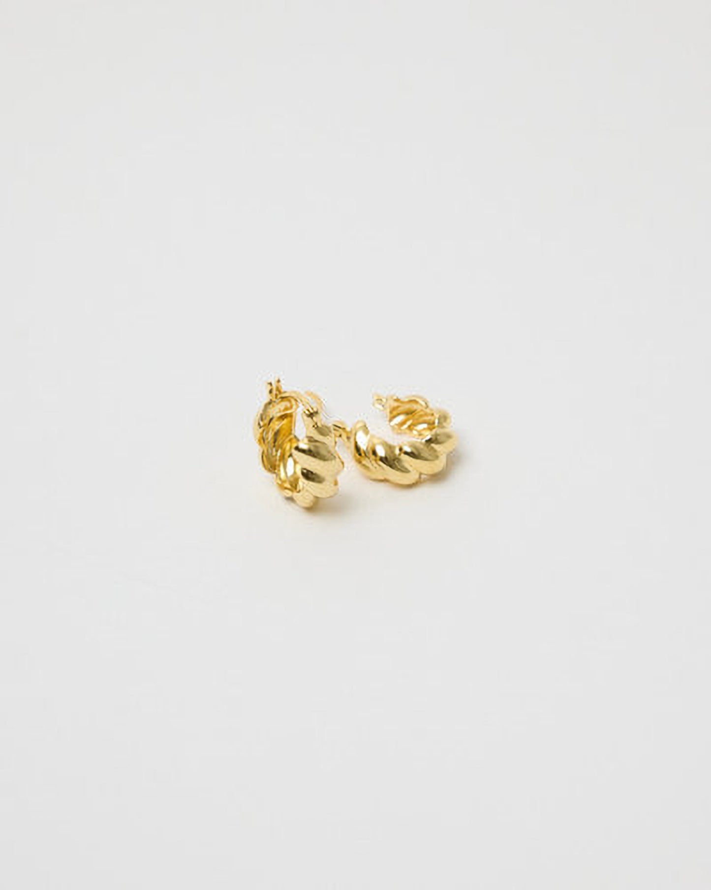 Gold hoop earrings on a light gray background