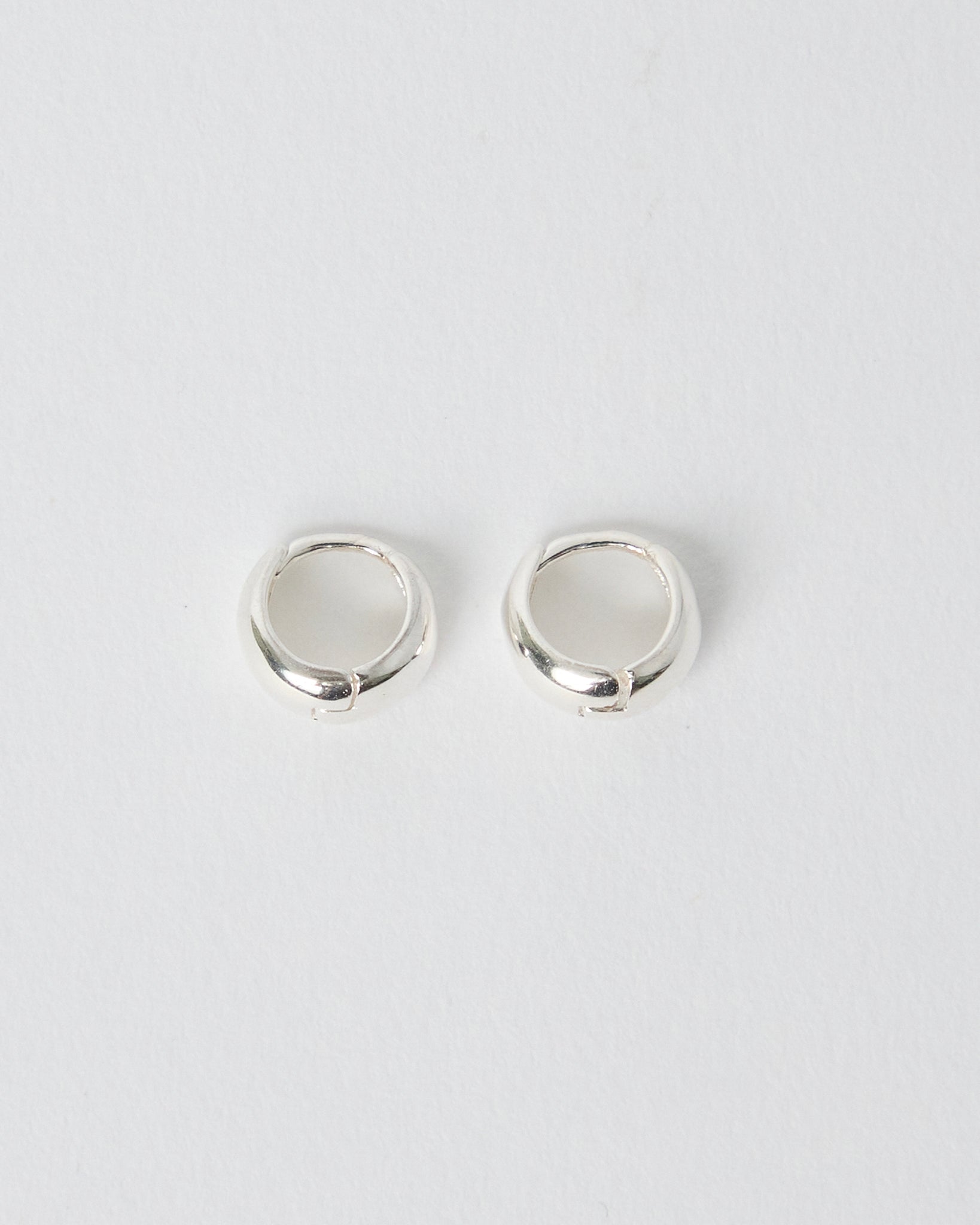 Pair of silver hoop earrings on a light gray background