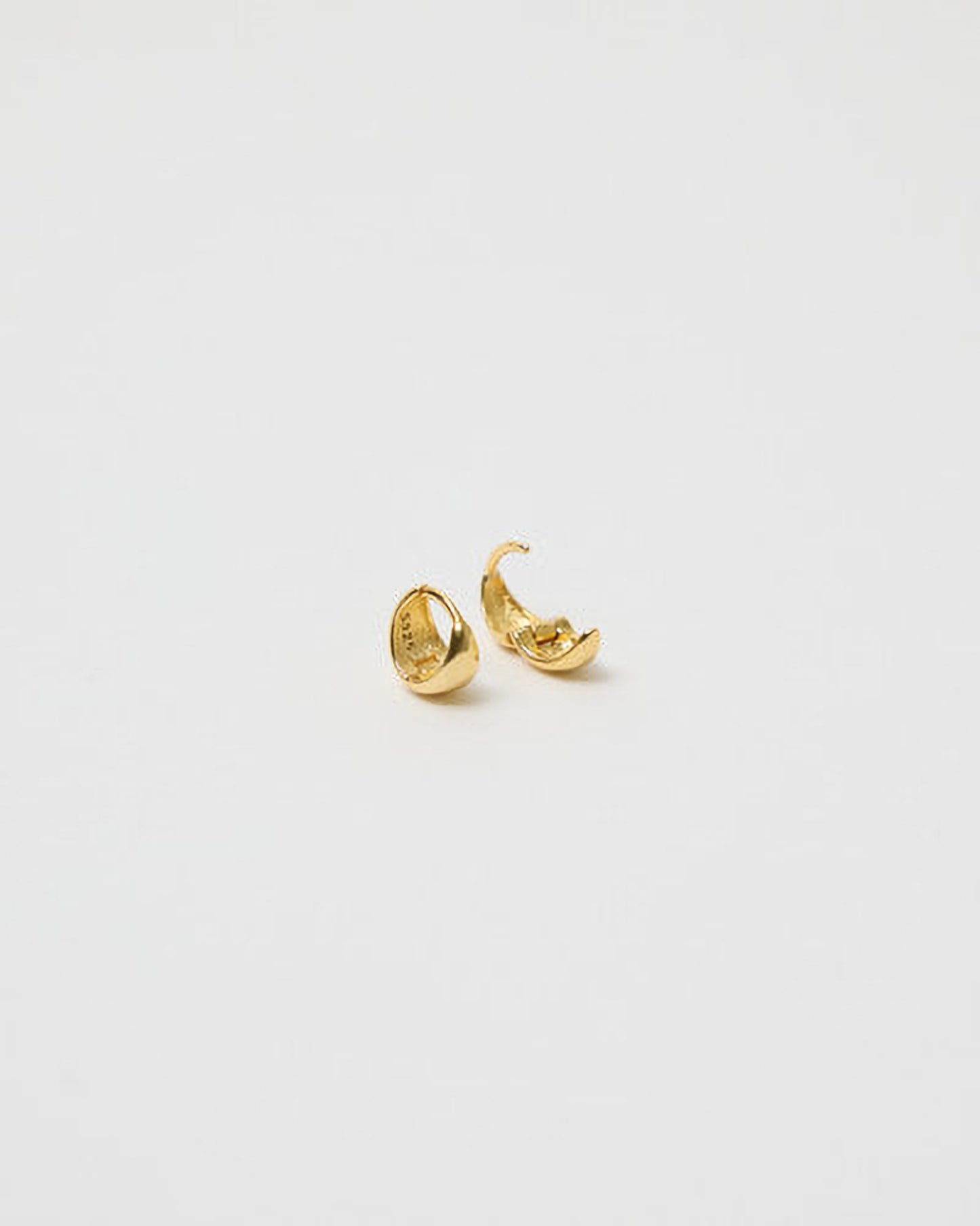 Gold hoop earrings on a light gray background
