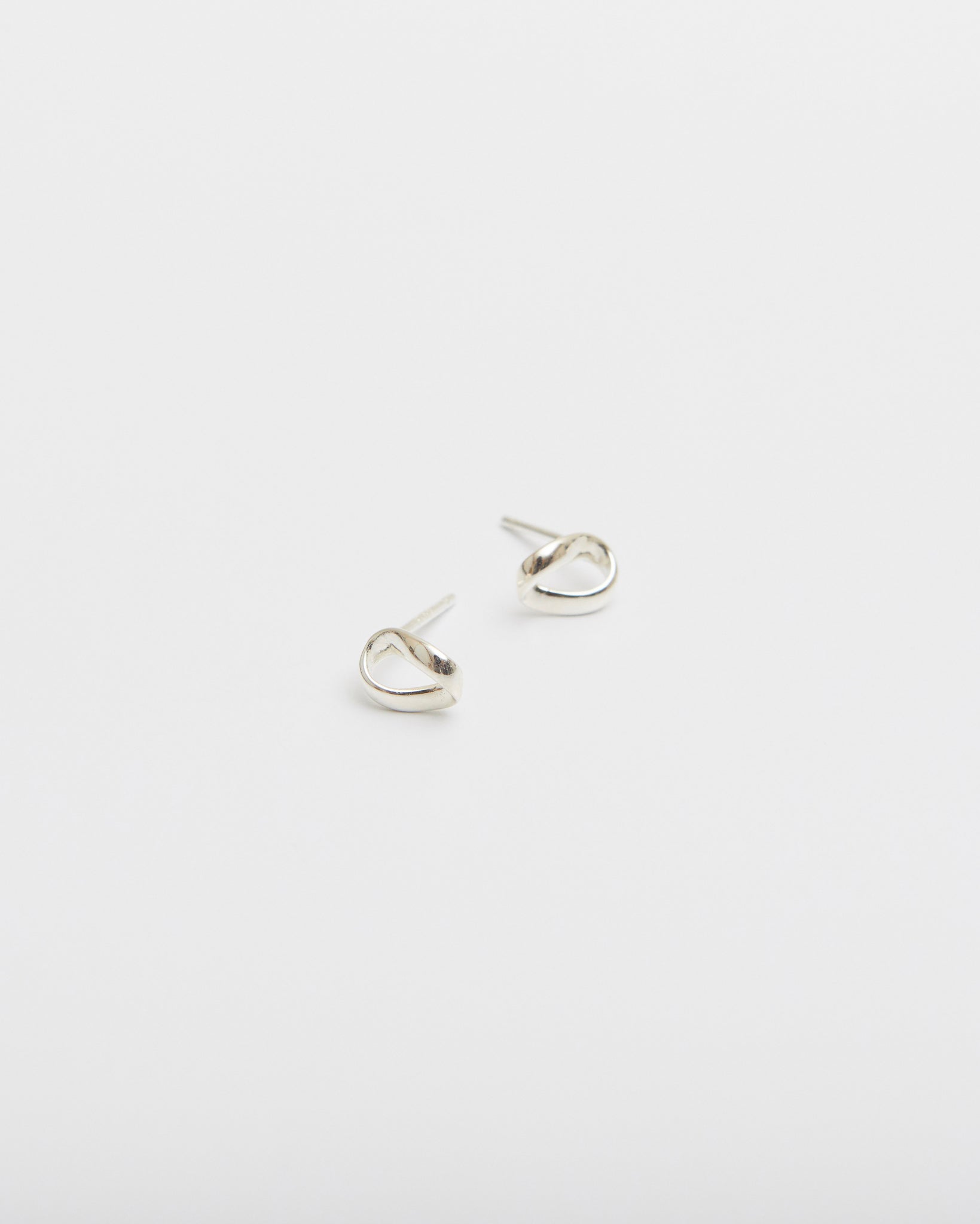 Pair of silver hoop earrings on a light gray background