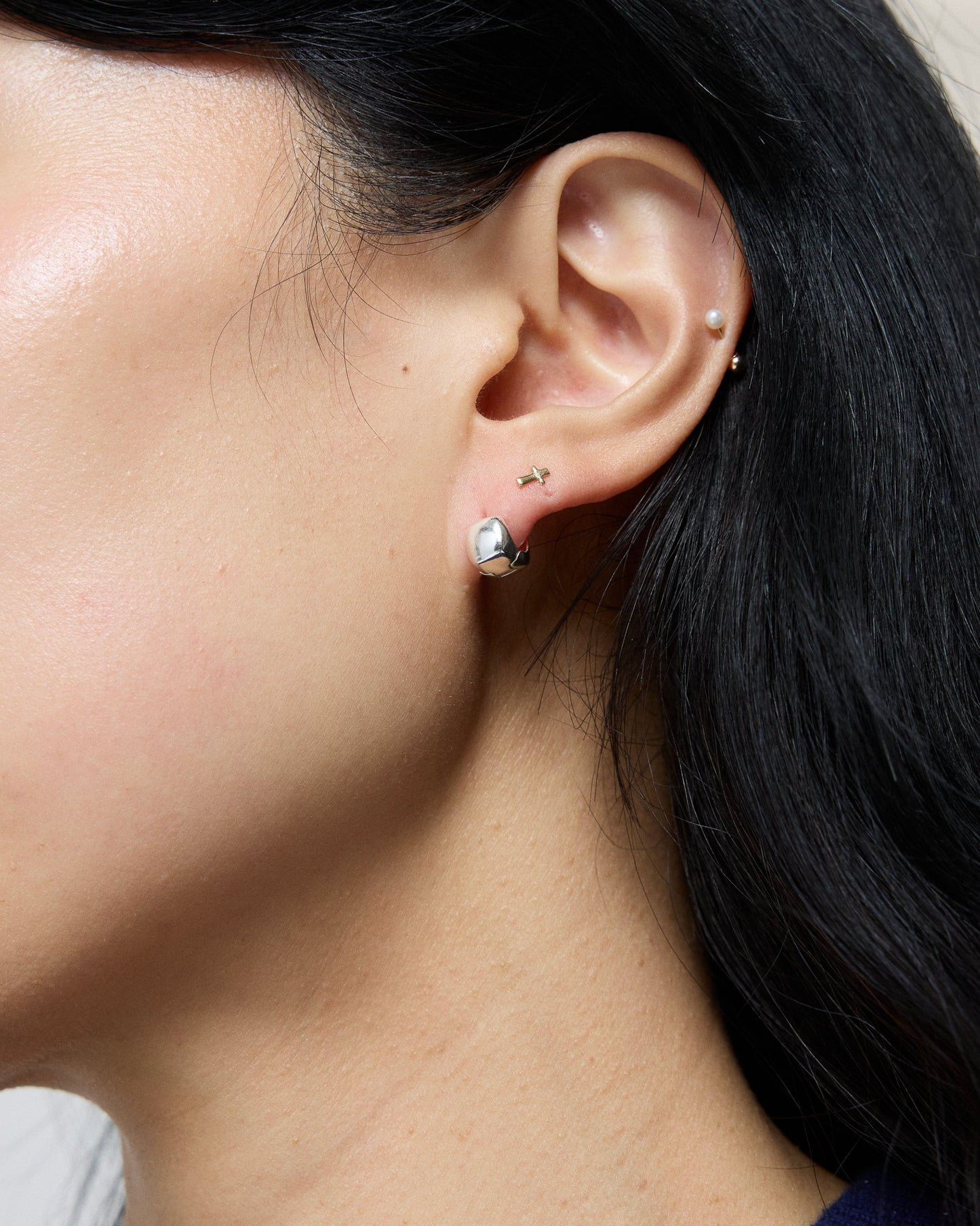 silver square stud earrings worn with layered ear styling, minimalist polished cube studs, modern everyday jewelry look