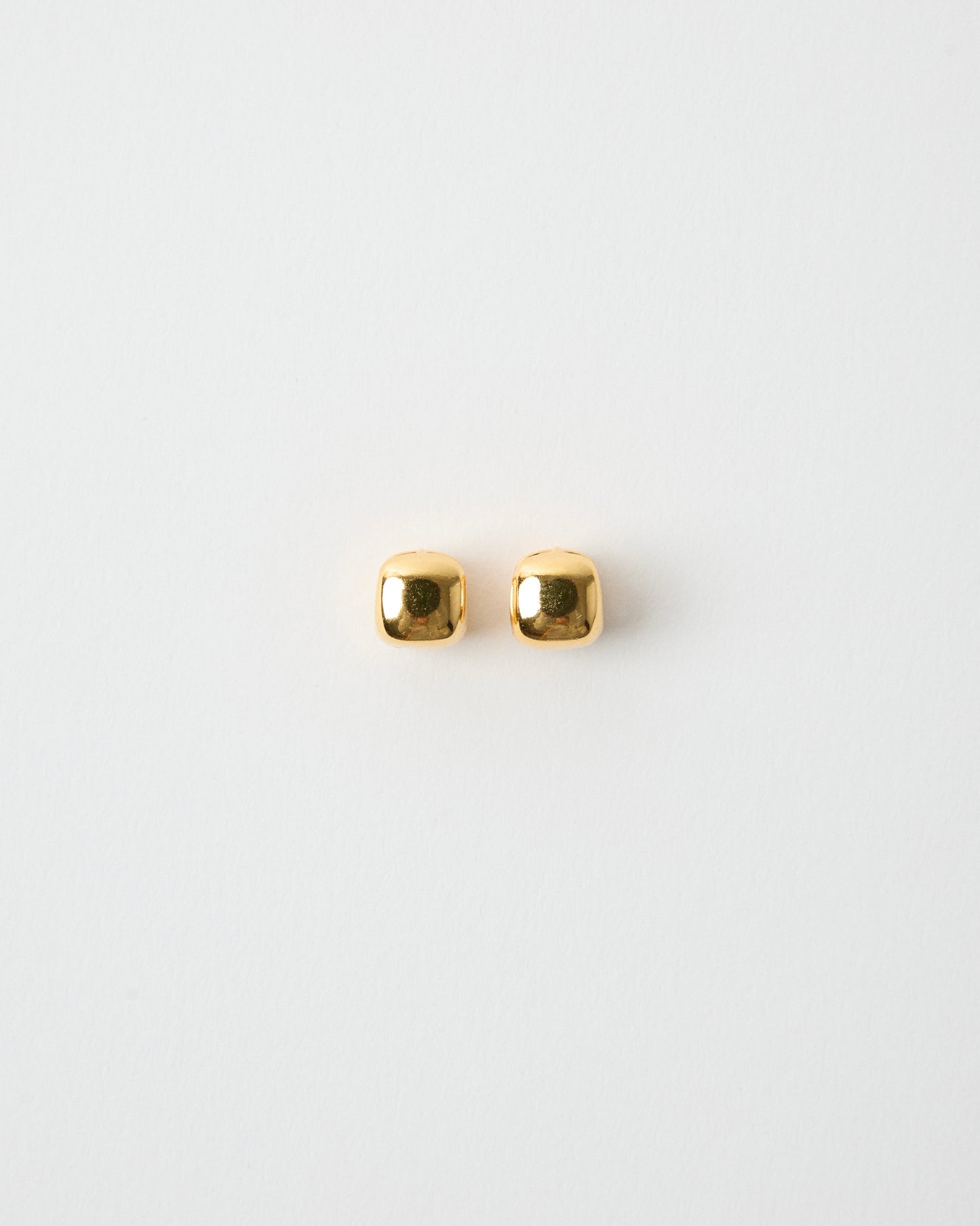 pair of gold square stud earrings on white background, polished rounded cube shape, minimal gold jewelry