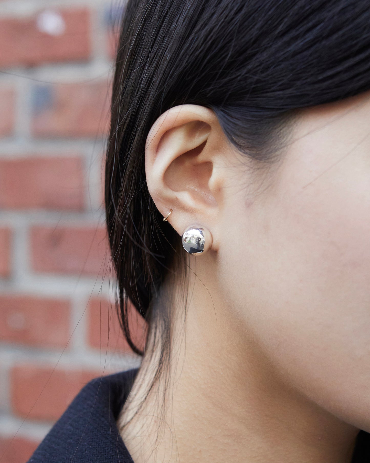 silver dome stud earrings worn on ear clean reflective minimal everyday styling