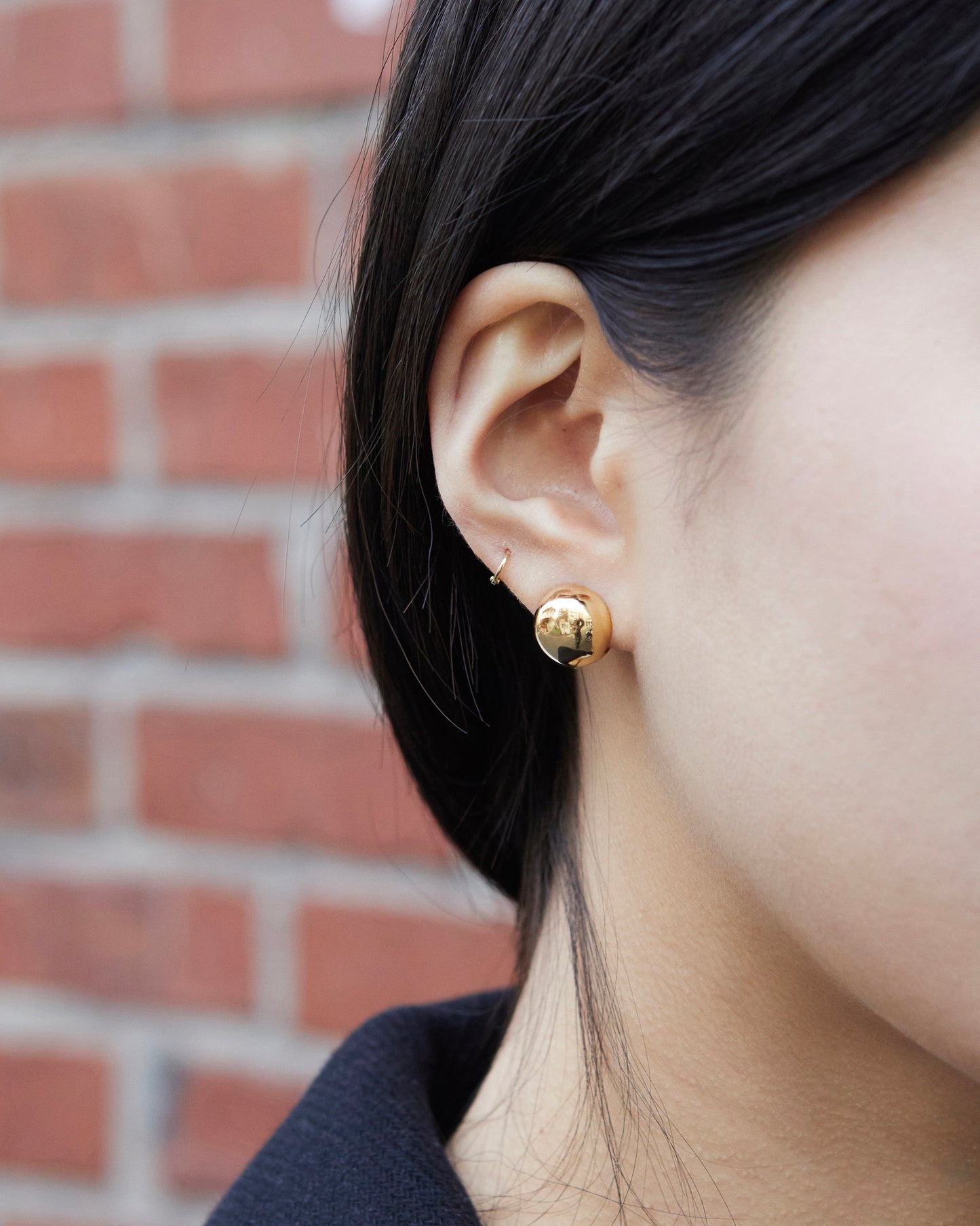 gold dome stud earrings worn on ear bold reflective minimal statement jewelry