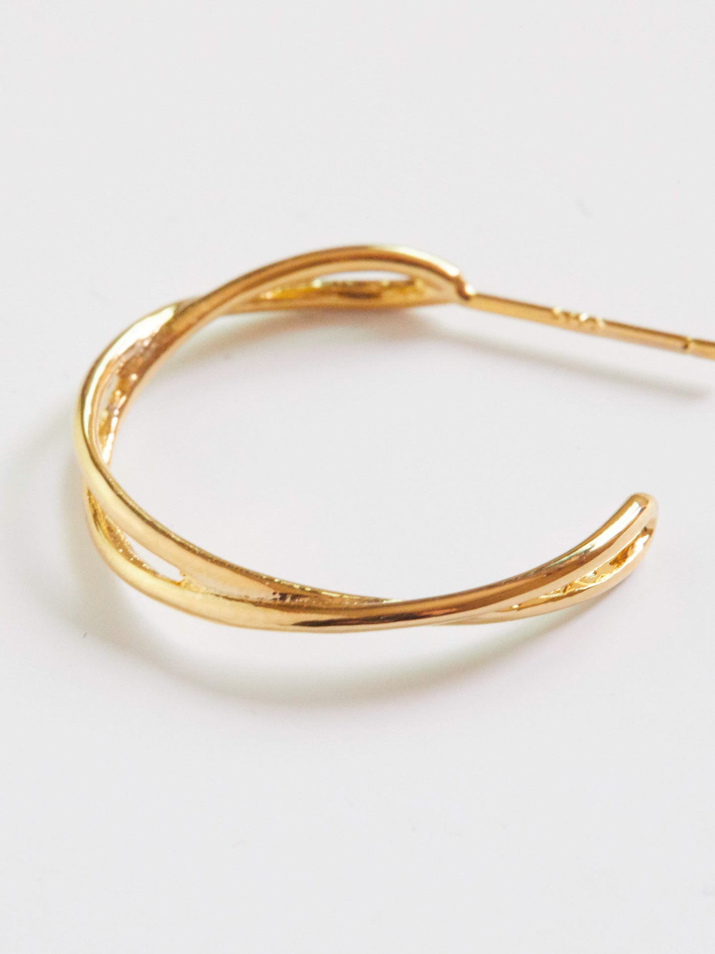 Gold earring on a light gray background