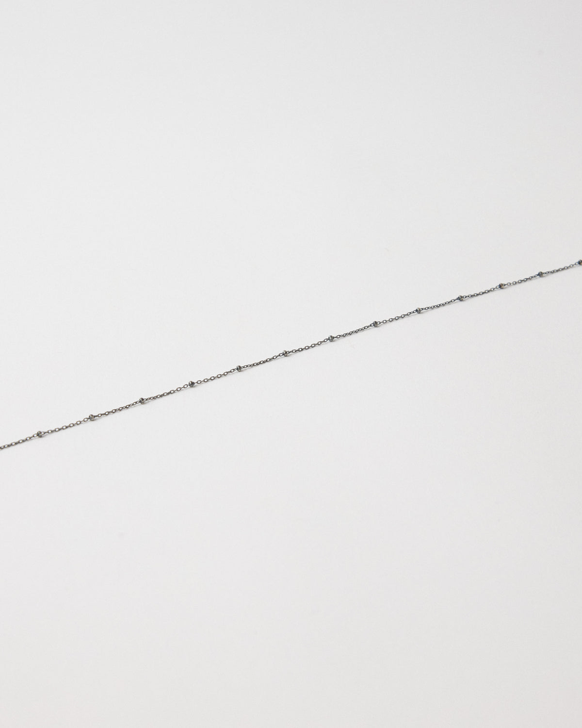 Close-up of an antique silver chain set with tiny dark silver balls – HANNA543 N1057 starlit dot chain
