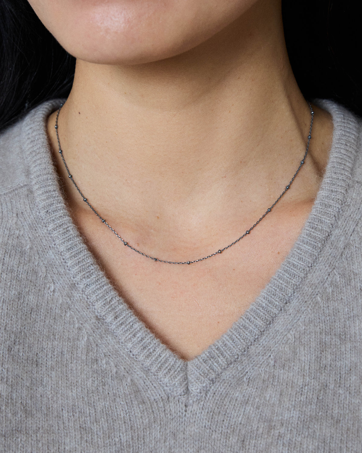 Antique silver dot chain necklace worn close to the neck with a gray sweater – HANNA543 N1057 starlit dot chain