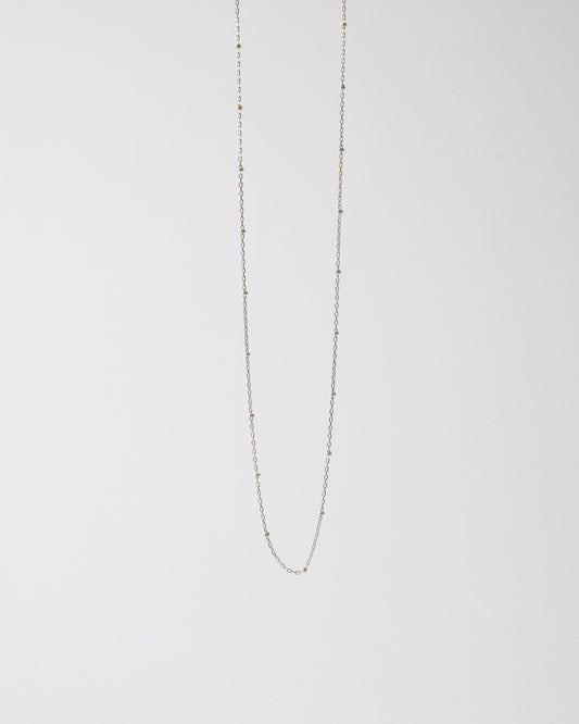 Sterling silver ball station chain necklace hanging on a light gray background – HANNA543 N1057 starlit dot chain