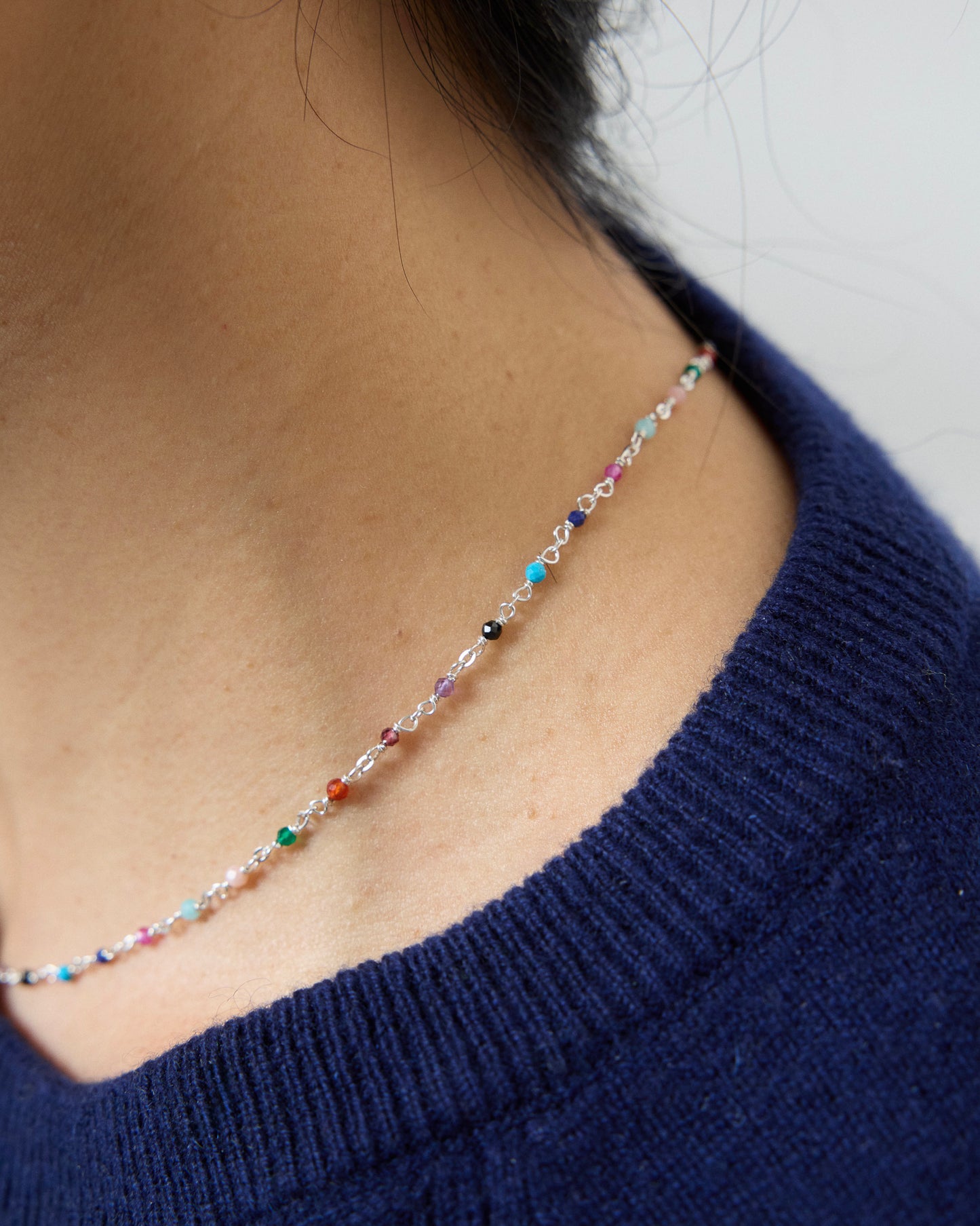 Woman wearing a colorful gemstone necklace on sterling silver chain