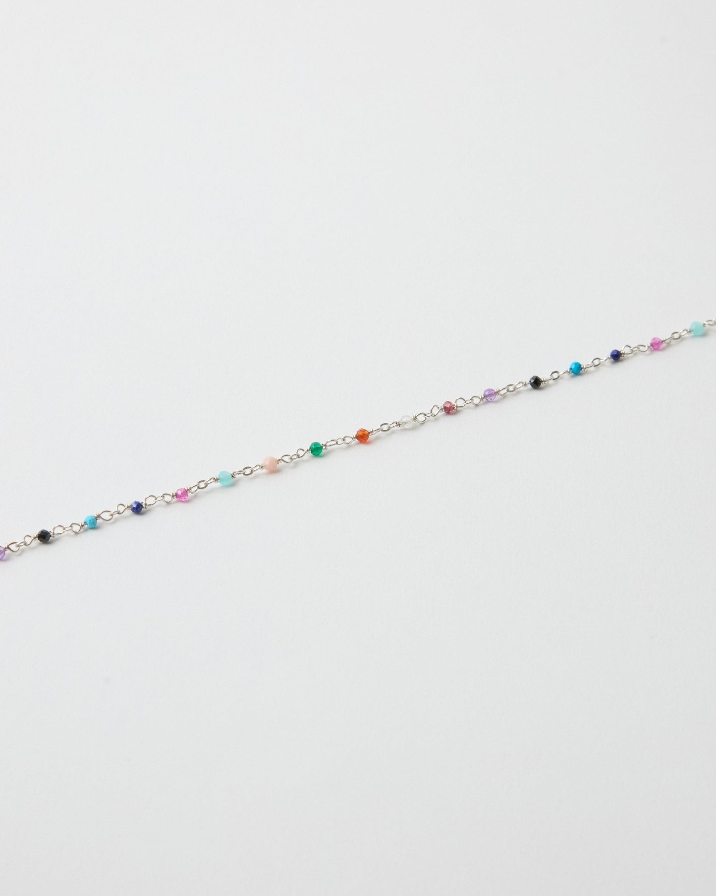 Close-up detail of colorful gemstone beads on sterling silver chain necklace