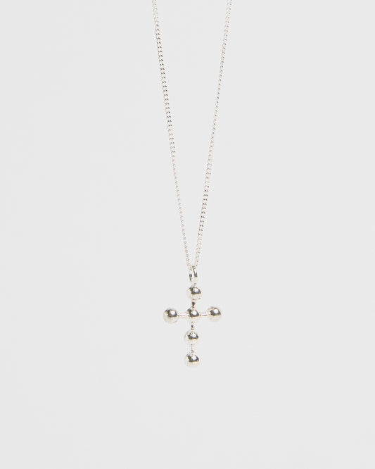 Silver cross pendant with orb accents, hanging from fine chain, isolated on white