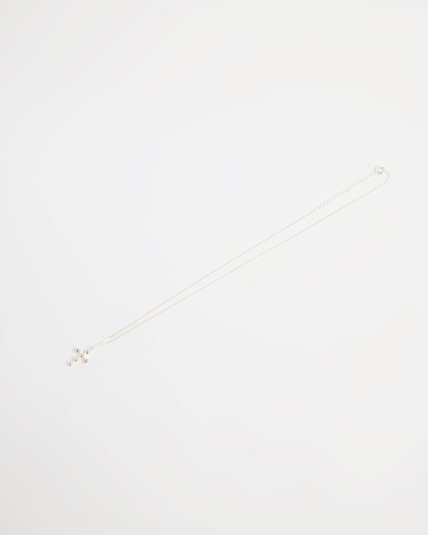 Full silver cross necklace with beaded design, laid flat on white background