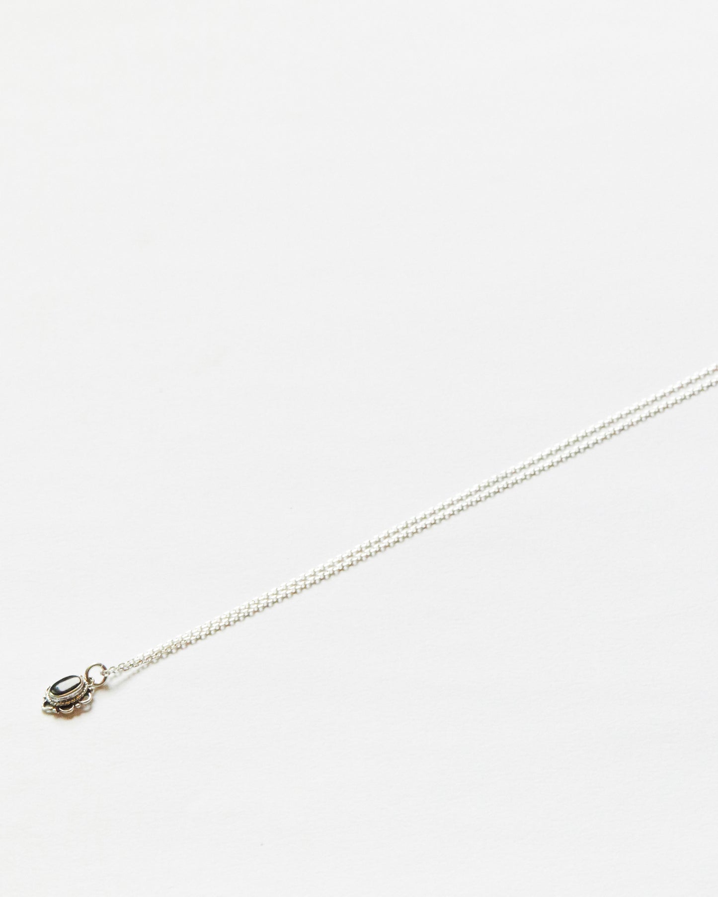 White stone necklace shown with chain fully extended, delicate and symmetrical