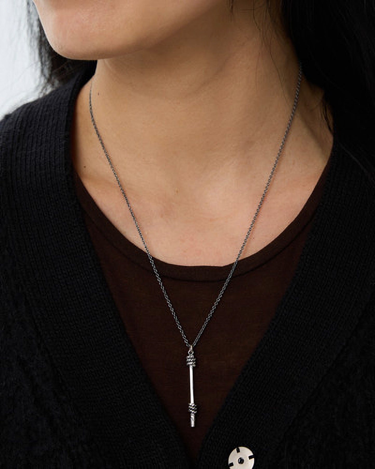 Person wearing a necklace with a unique pendant