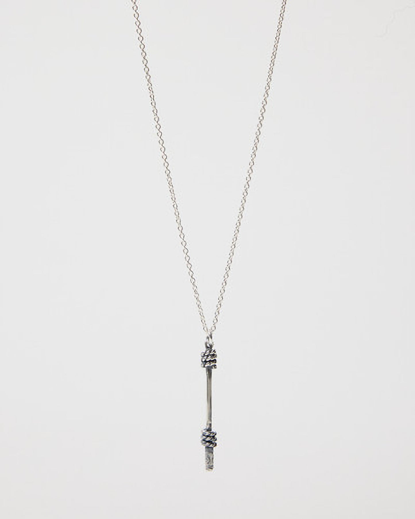 Silver necklace with a unique pendant on a light gray background