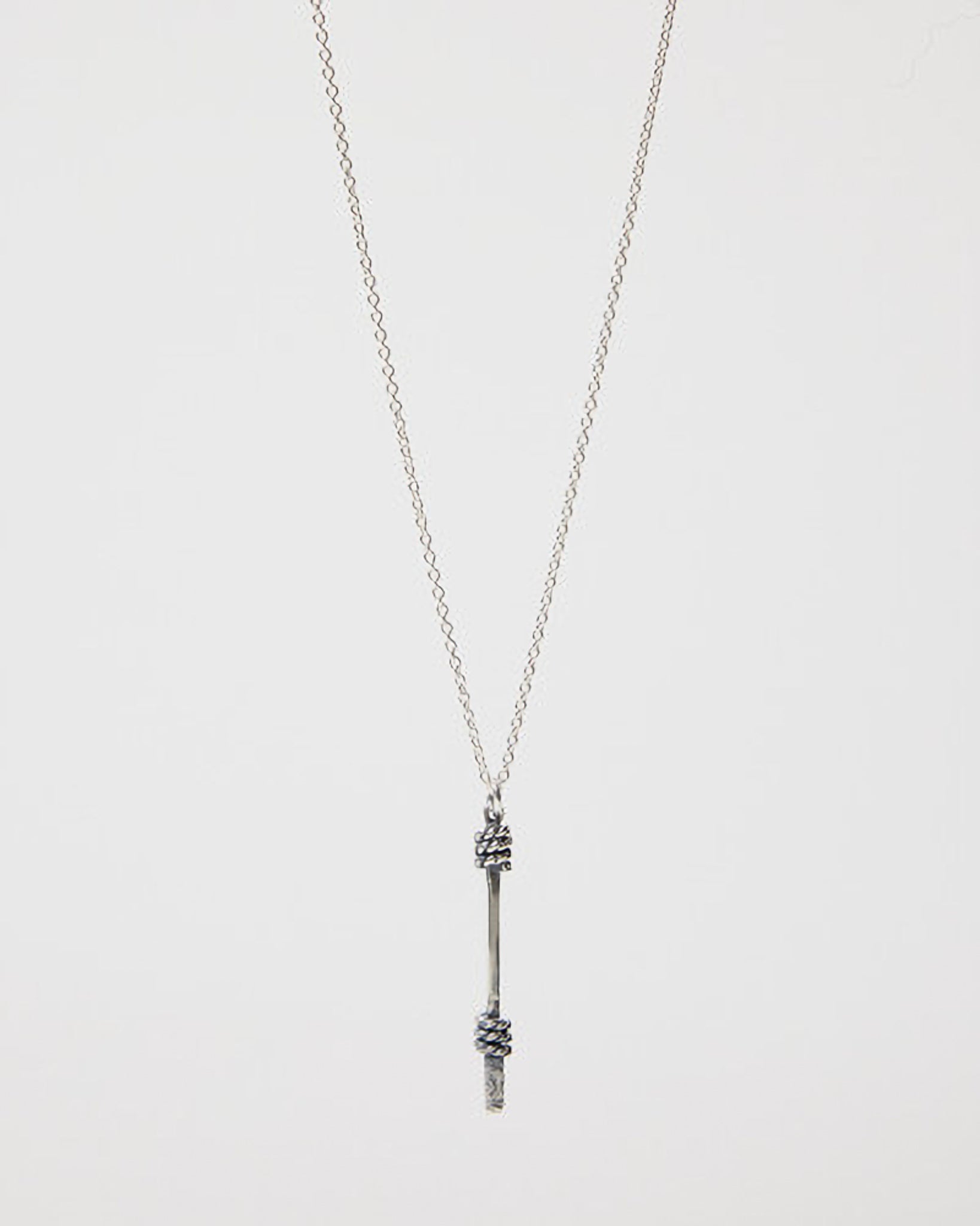 Silver necklace with a unique pendant on a light gray background