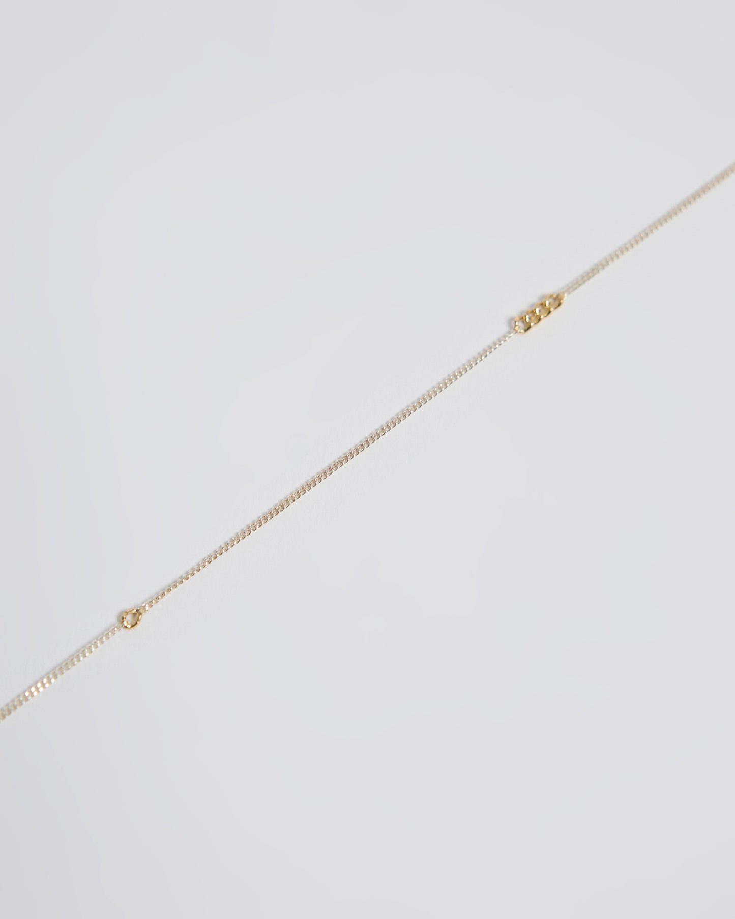 Close-up detail of sterling silver chain necklace with interconnected gold links